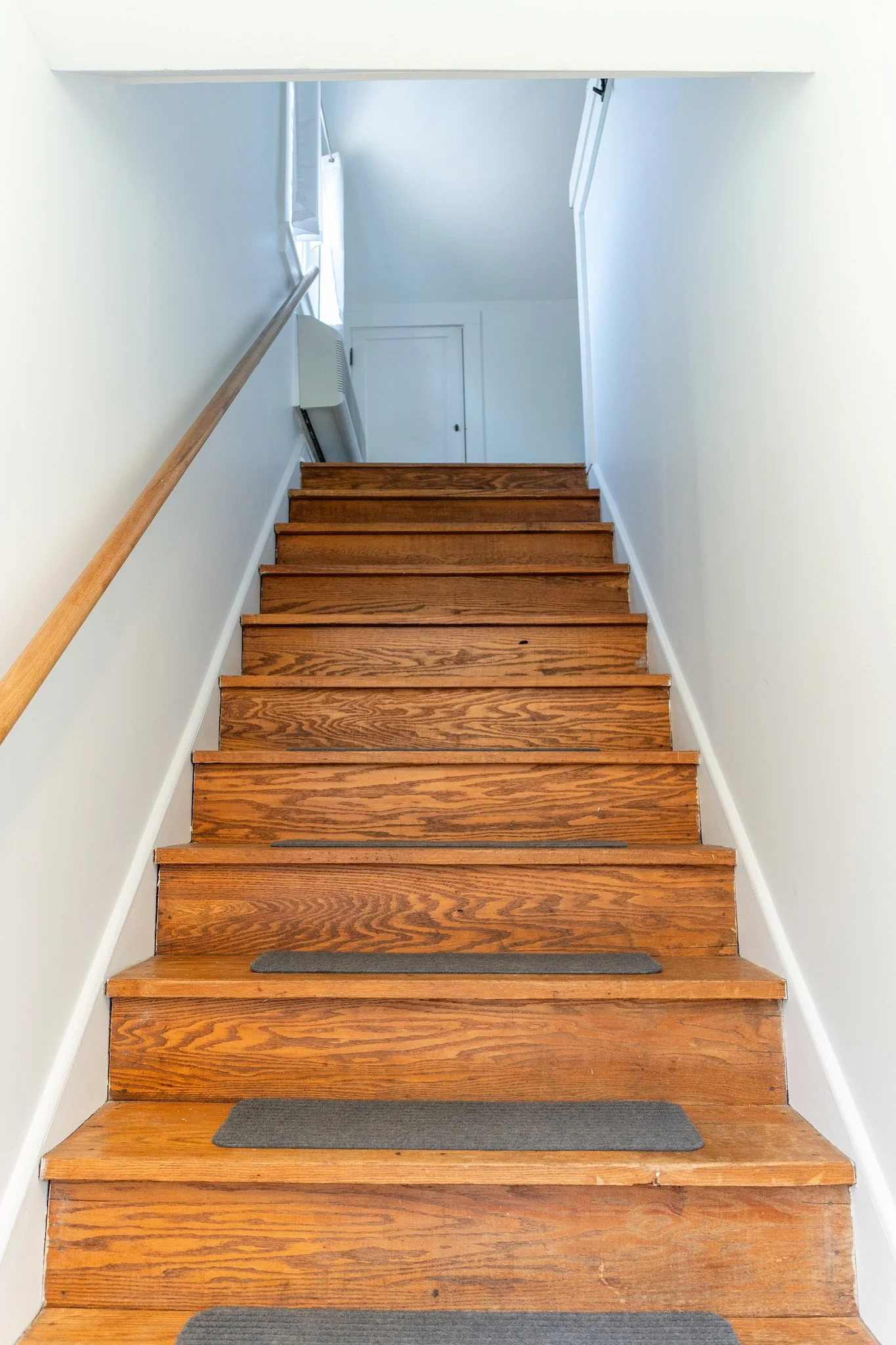 Wooden staircase leading to the Cloud 9 Loft Apartment at New River Nooks in Fayetteville WV.
