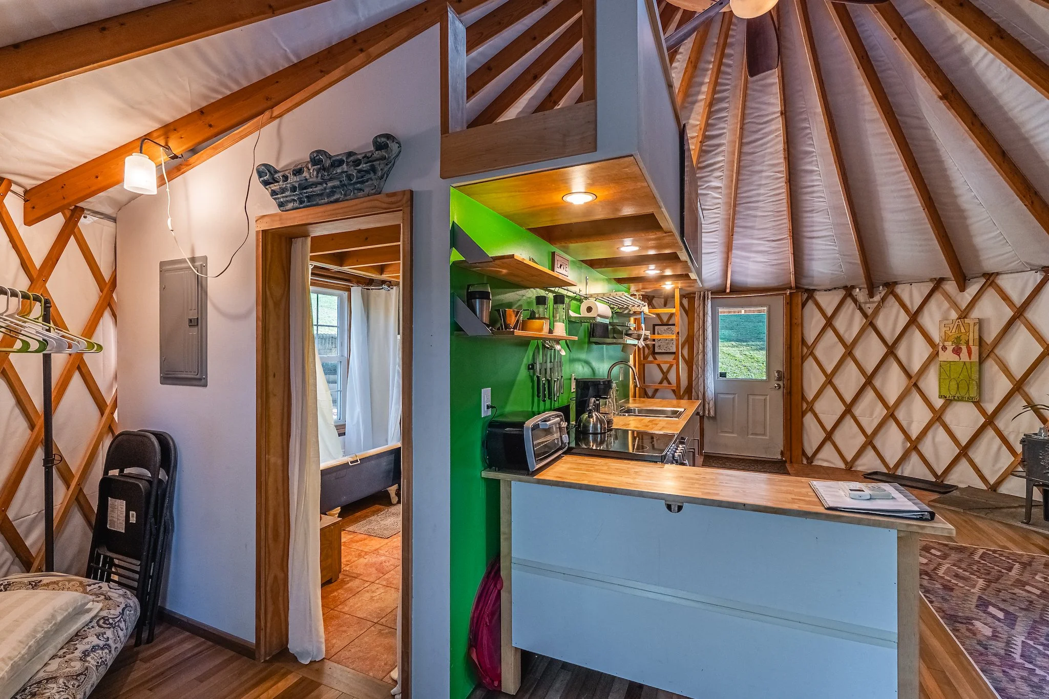 interior of yurt showing kitchen area and door to bathroom in New River Gorge WV.