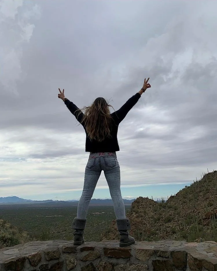 Woman standing with power pose looking across the desert. DBT counseling.