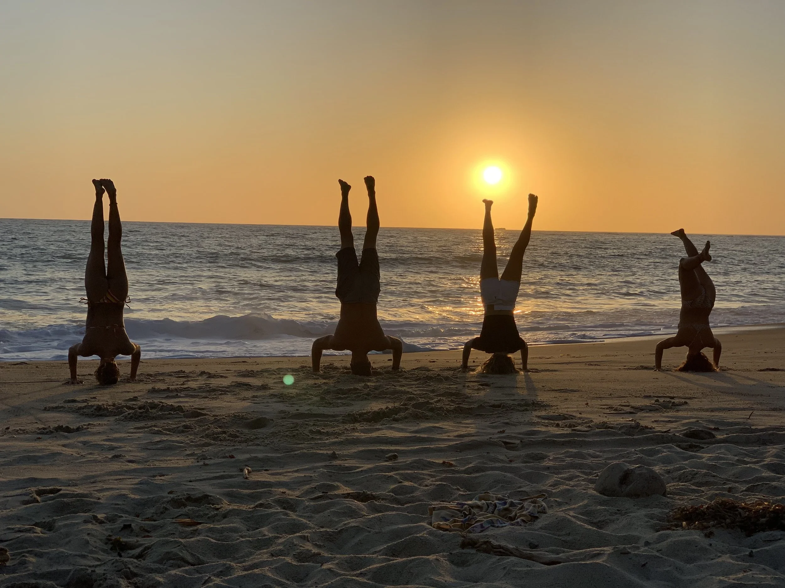 A faimily standing on their head watching the sunset and practicing mindfulness.