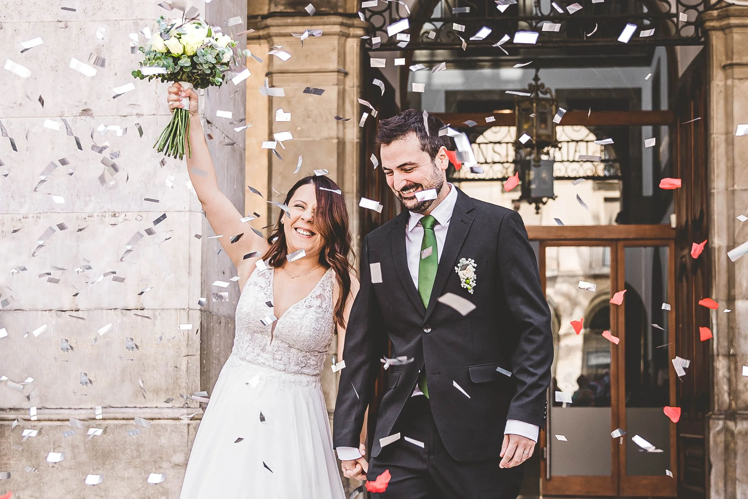 Bride and groom smiling during their just married confetti exit