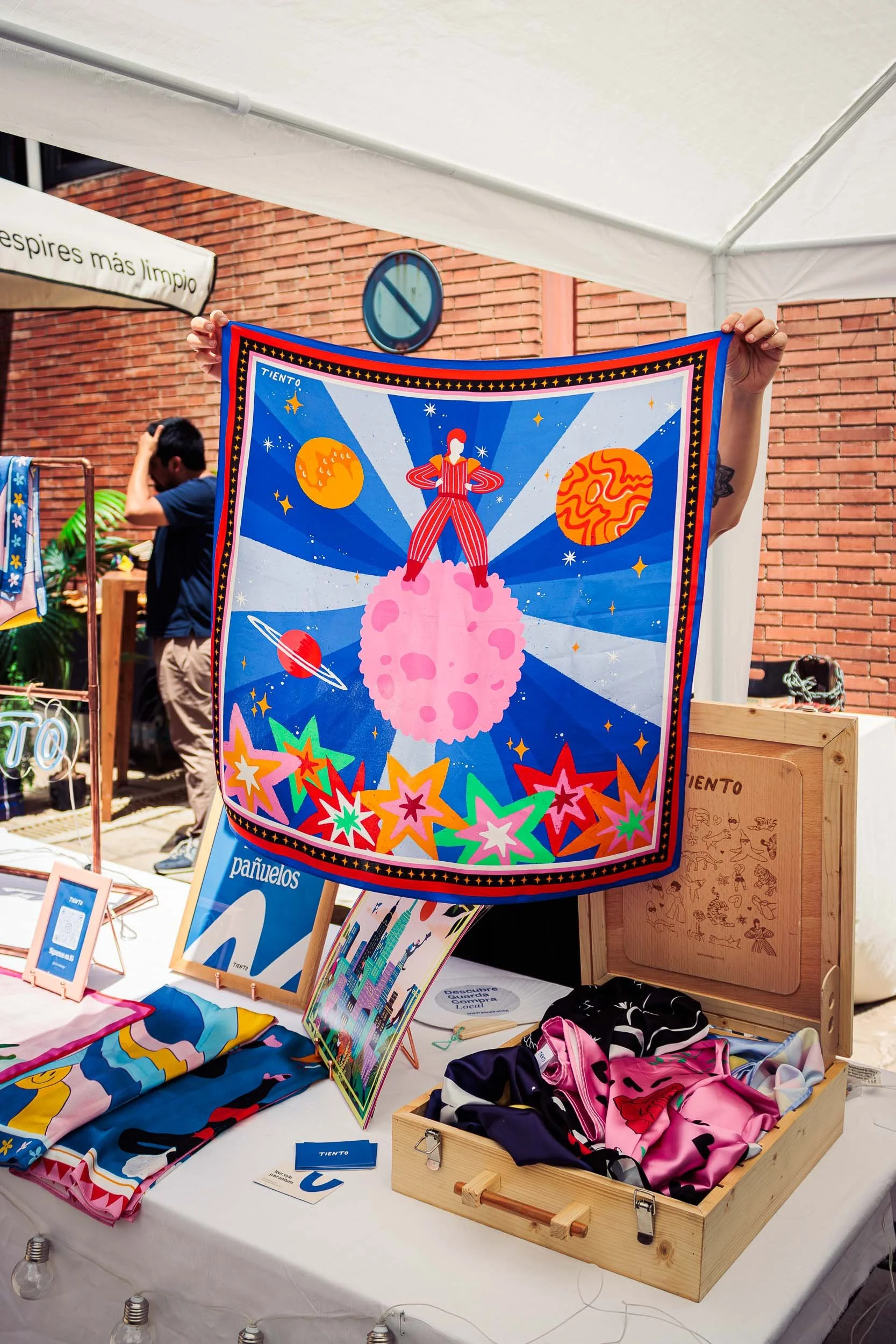 Colourful textile wall hanging displayed at a brand booth during a lifestyle event
