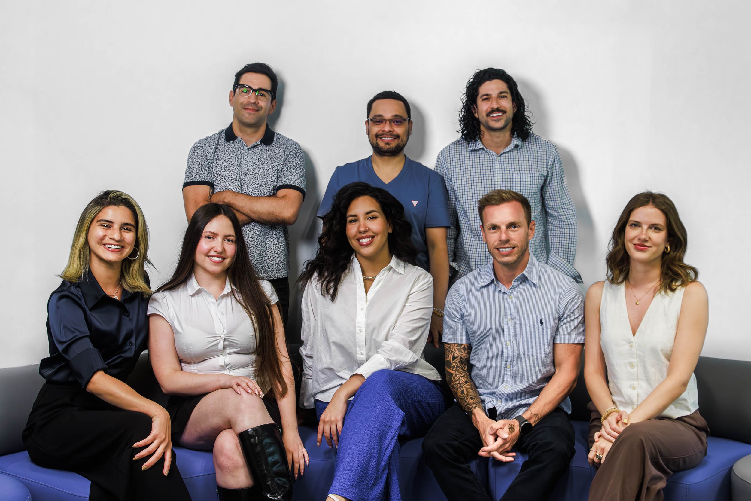 Group photo of the OQtima team seated and standing together in an office