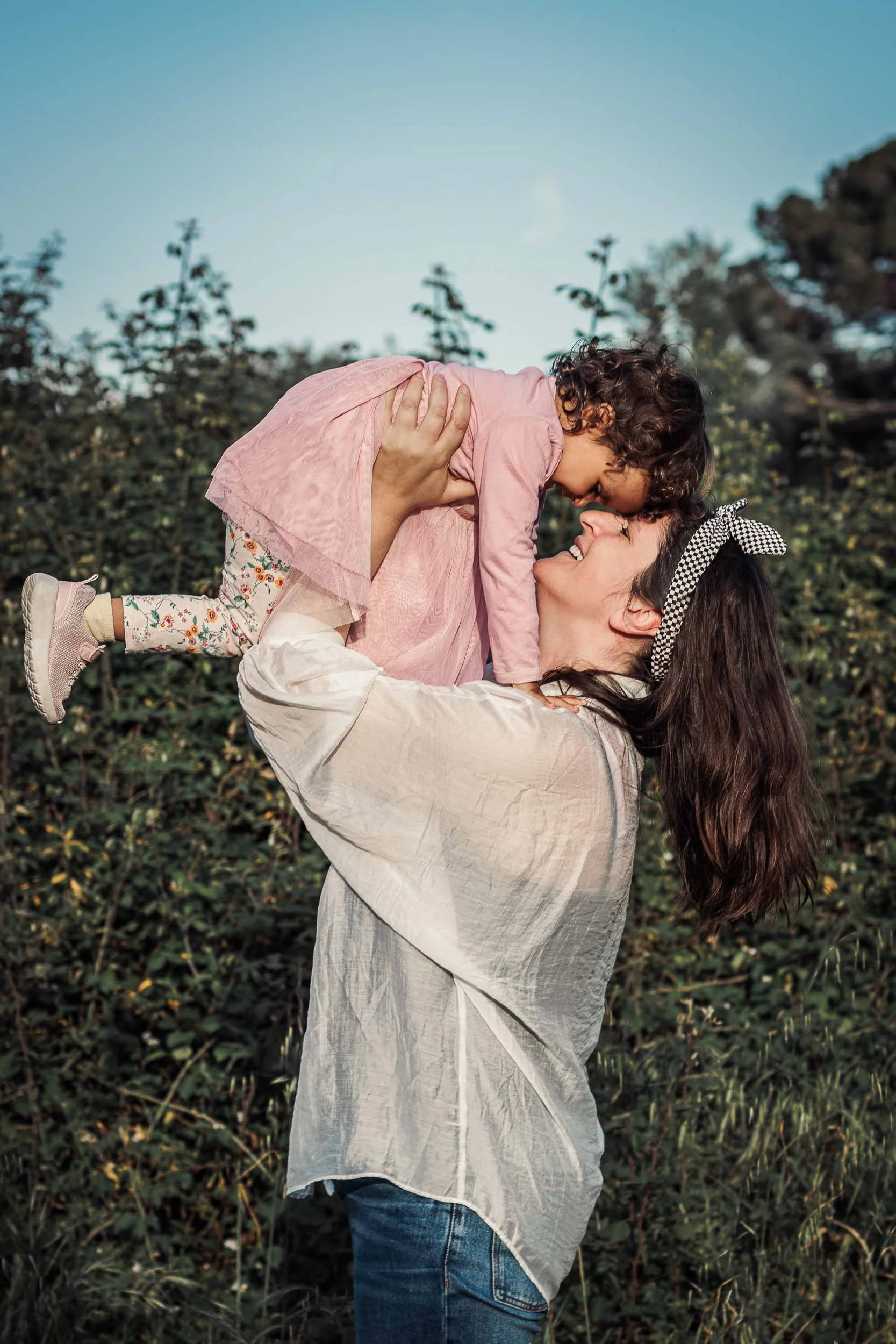 Portrait of a mother lifting her daughter during an outdoor family session