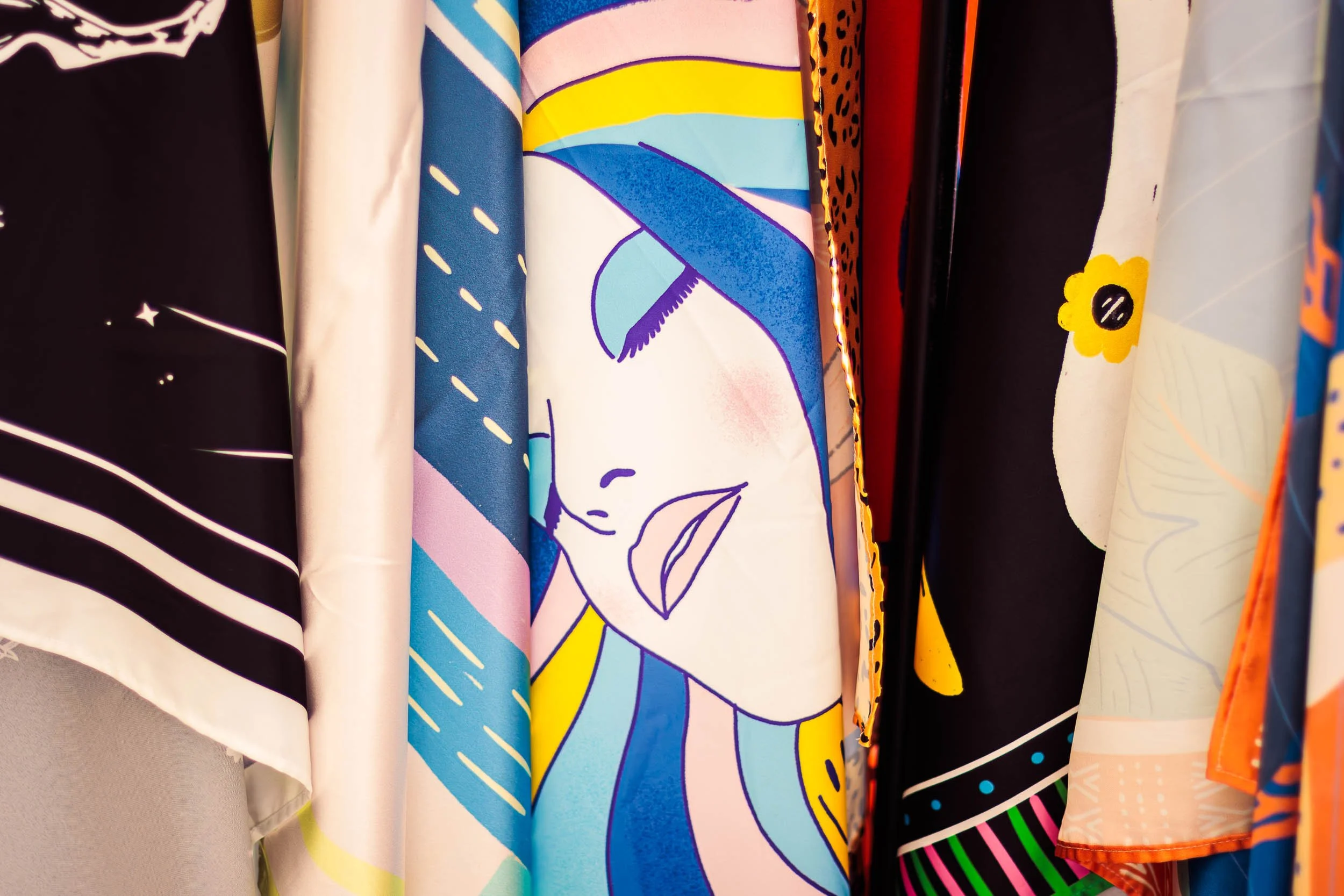 Colourful textile wall hanging displayed at a brand booth during a lifestyle event