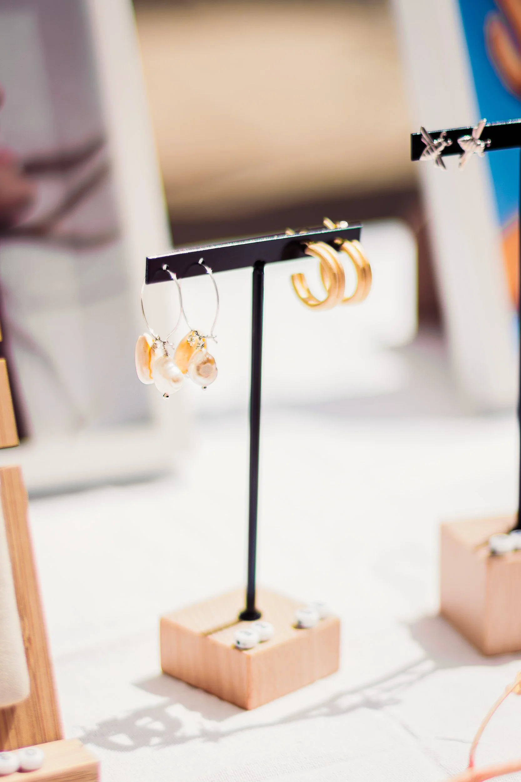 Gold jewellery arranged on stacked wooden display trays at a showroom event