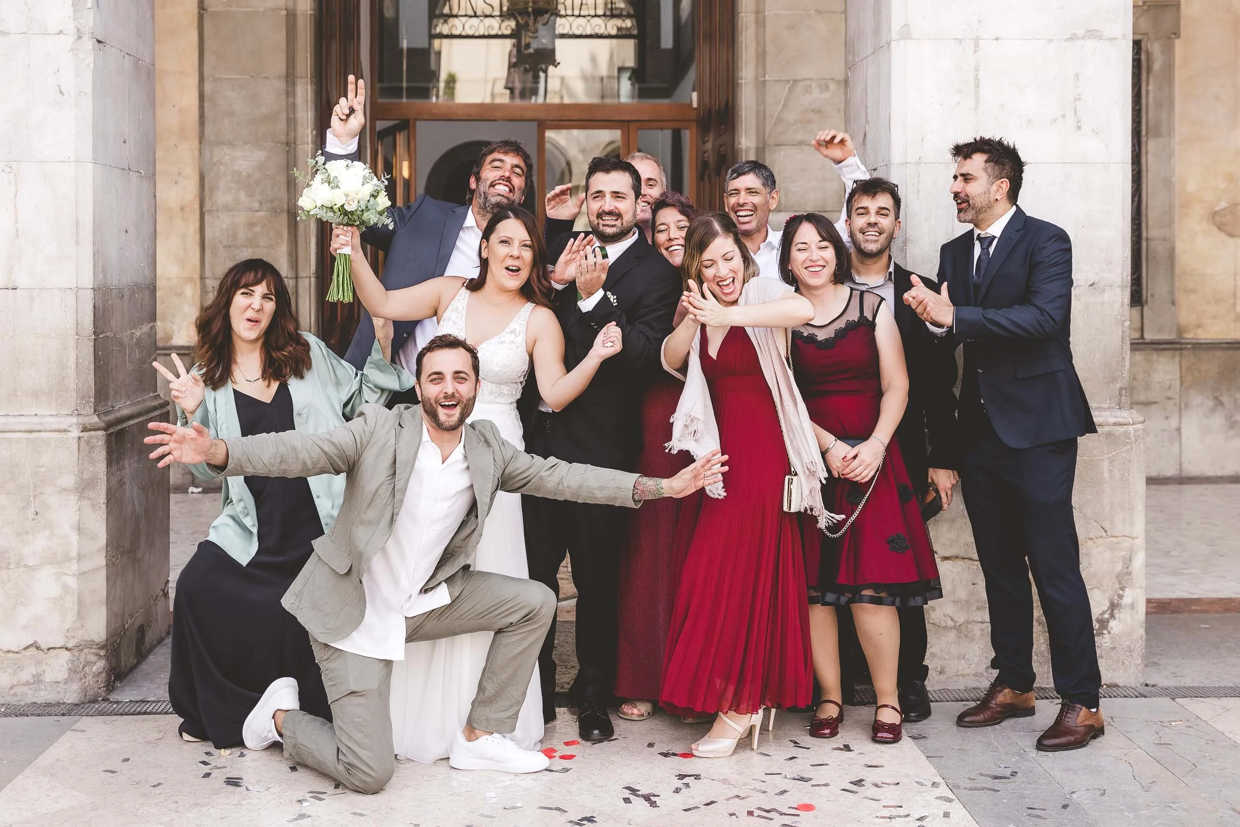 Bride and groom posing with friends outside the ceremony entrance