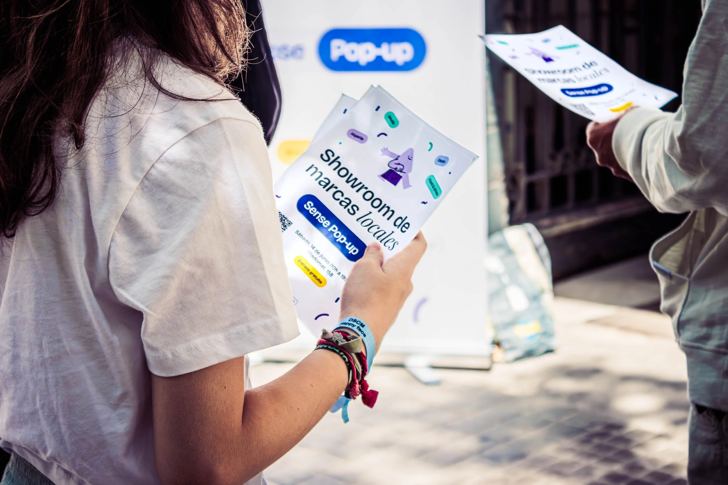 Close-up of a person holding an event flyer while walking through the venue
