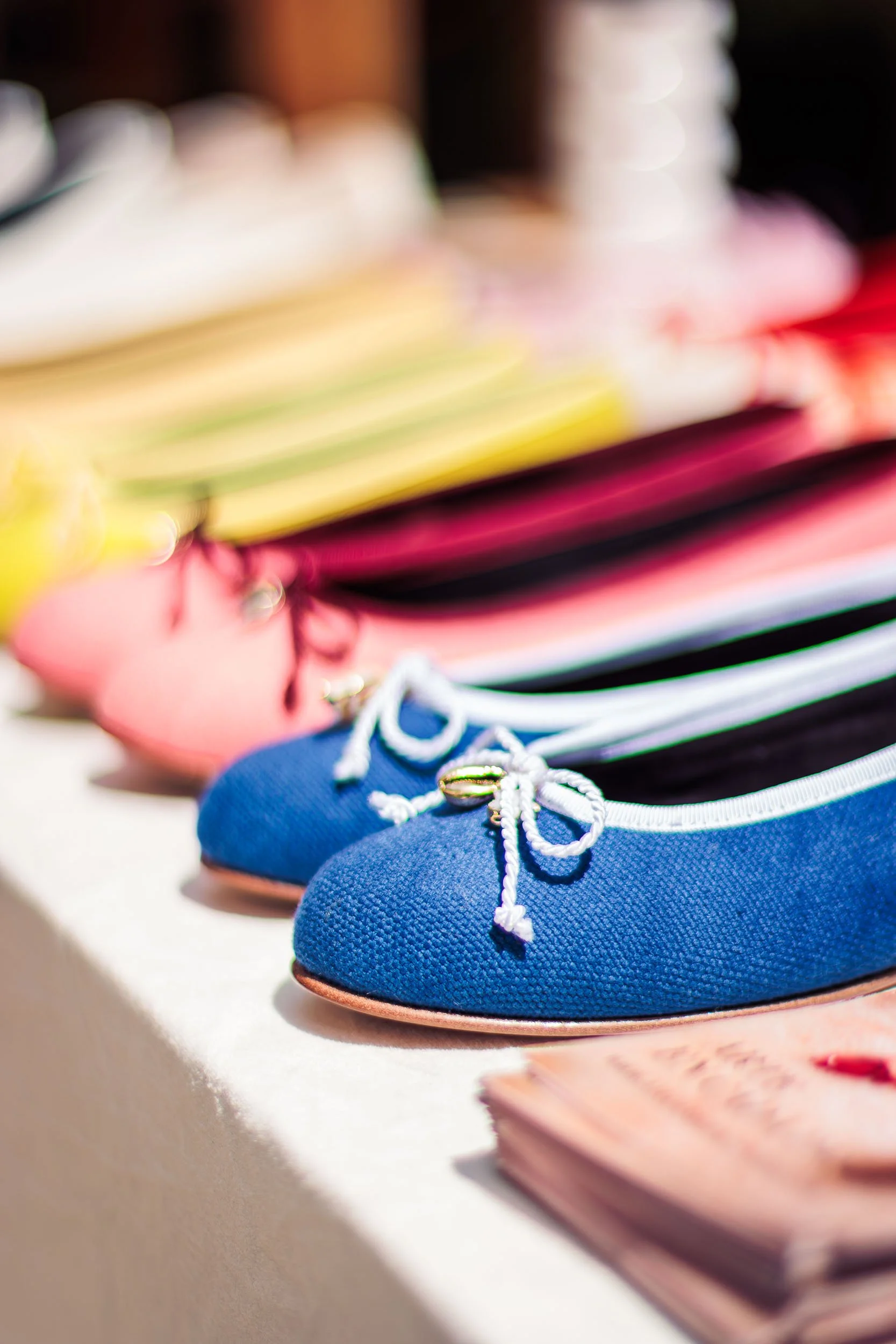 Product photo of colourful ballerinas with a blue pair being in the foreground