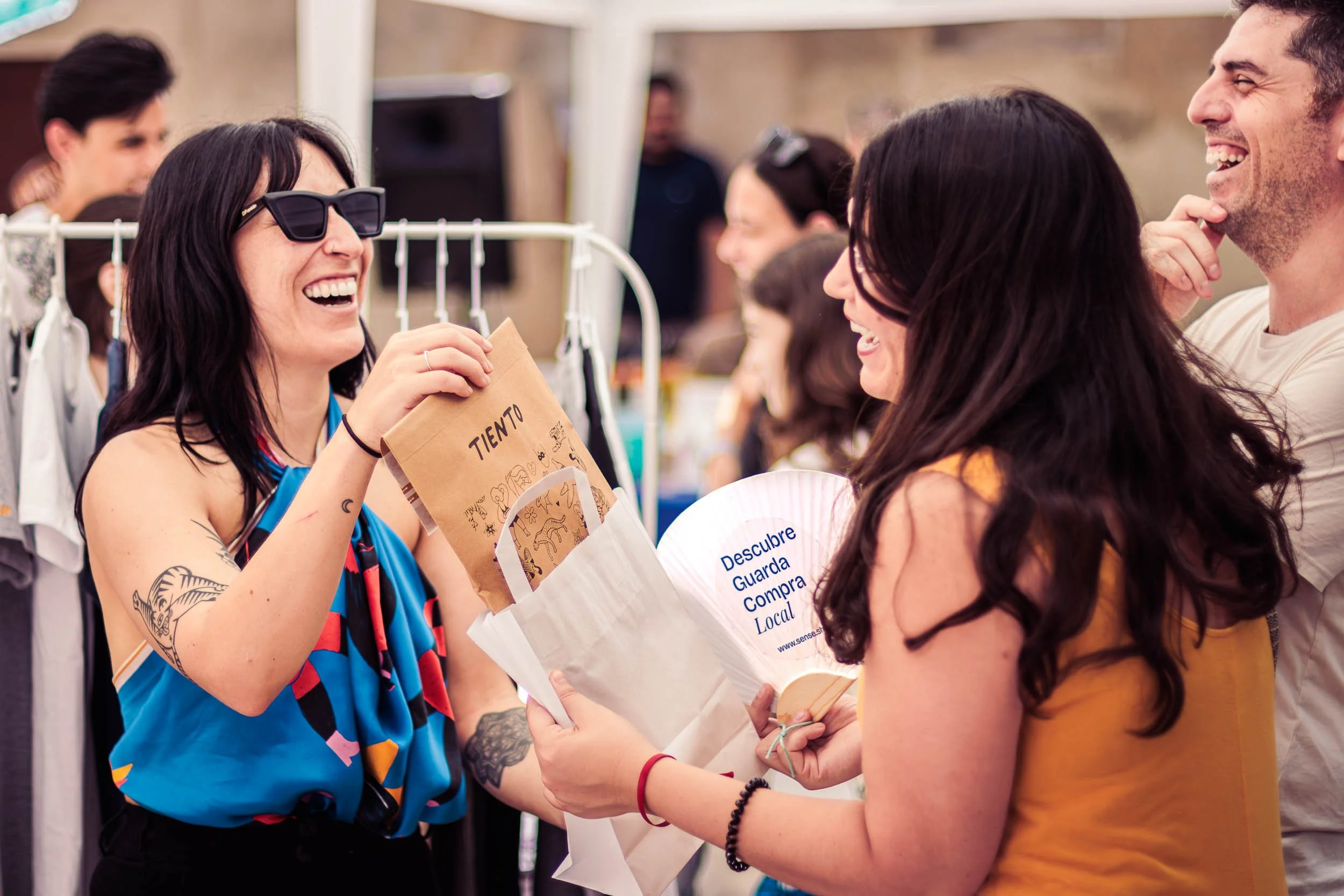 People smiling and talking at an outdoor event.