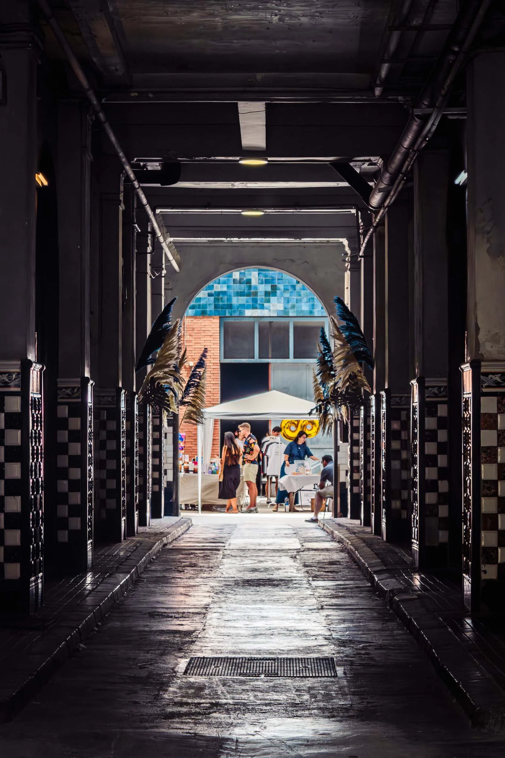 View through a dark industrial corridor leading into the event space