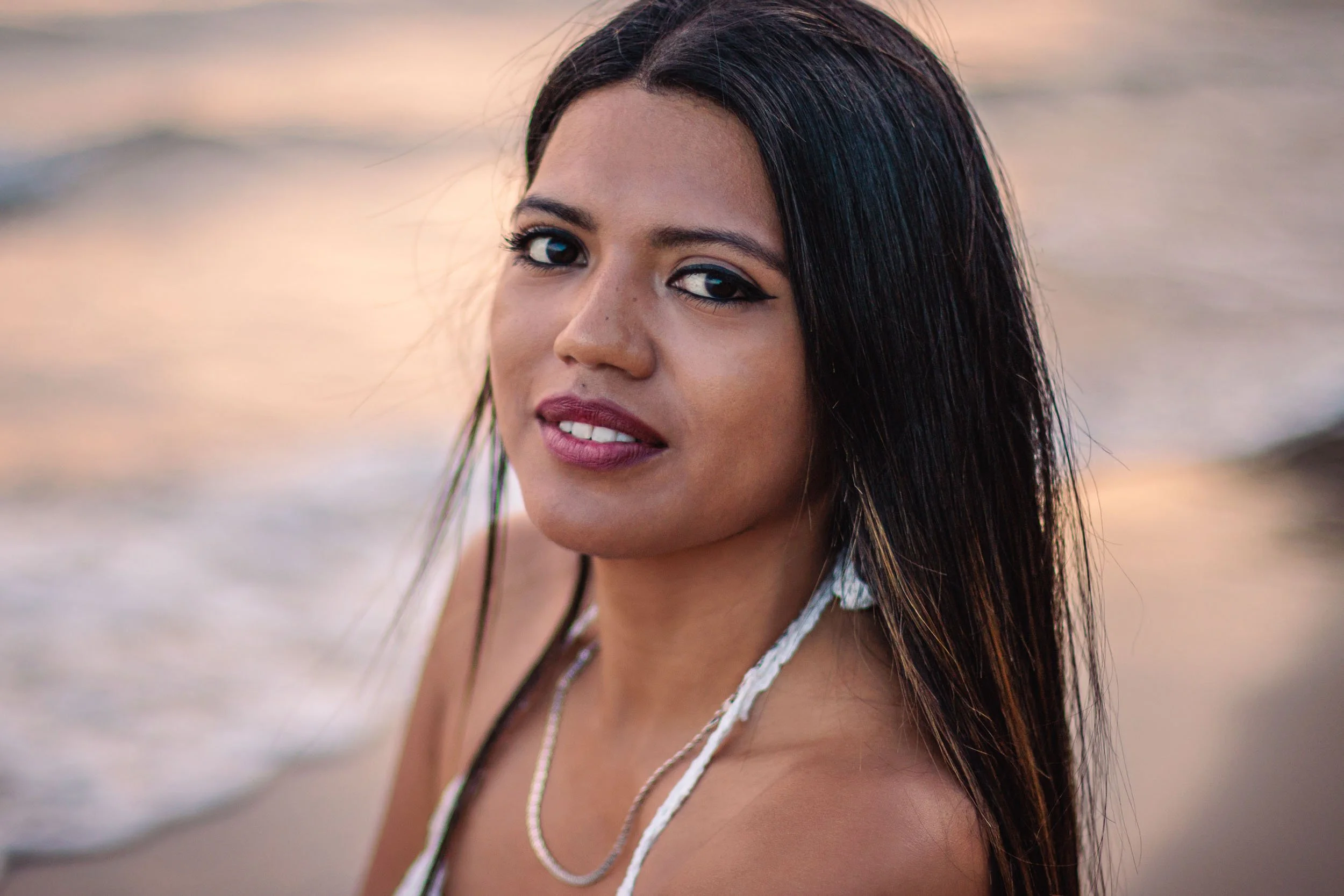 Close-up portrait of a woman by the sea during sunset