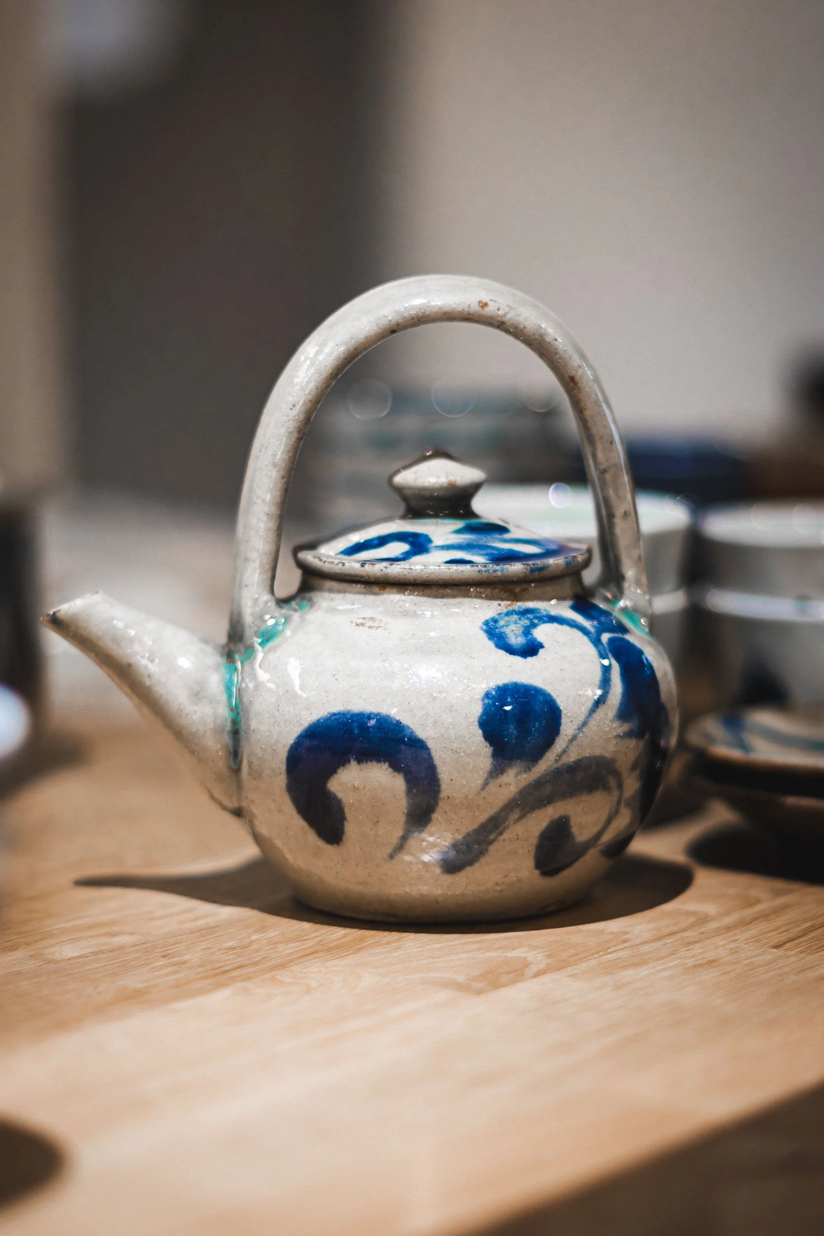 Ambience restaurant detail showing blue and white ceramic teapot on a wooden table