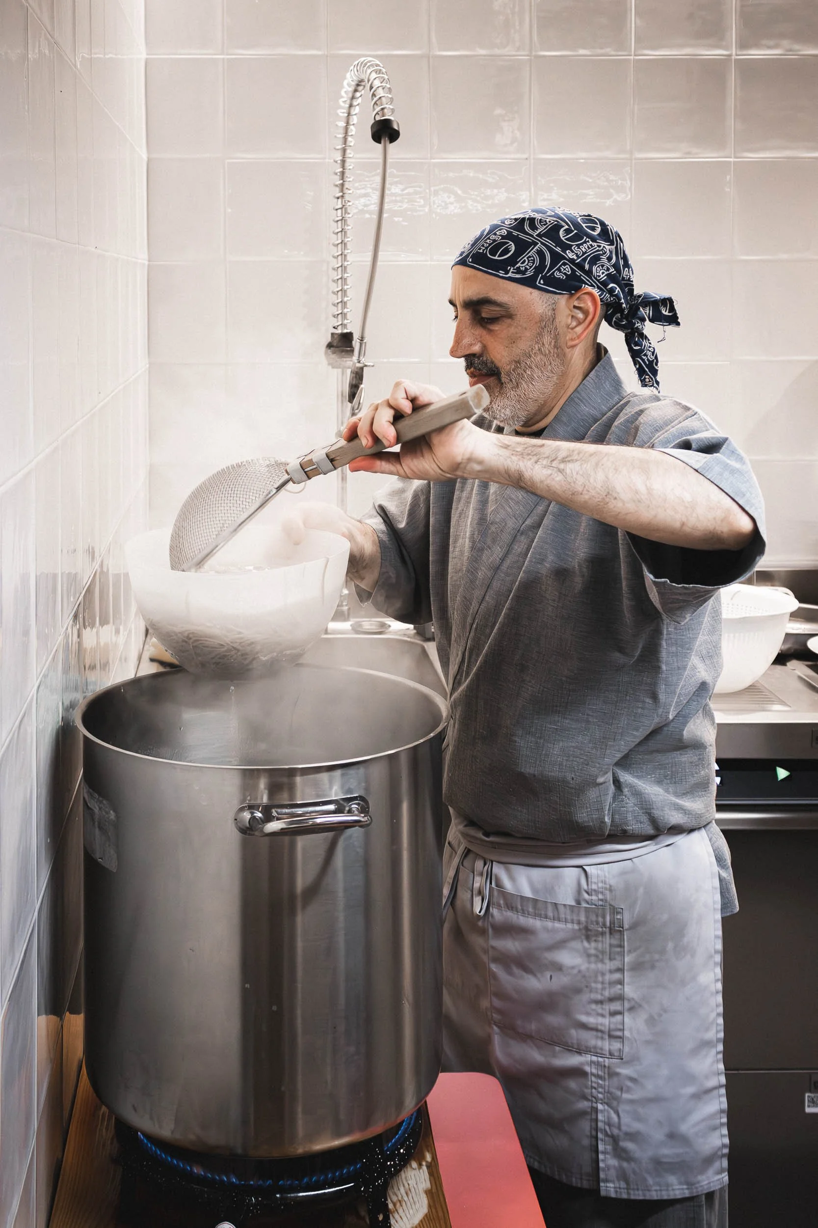 Chef stirring a large pot in the kitchen at a Barcelona restaurant