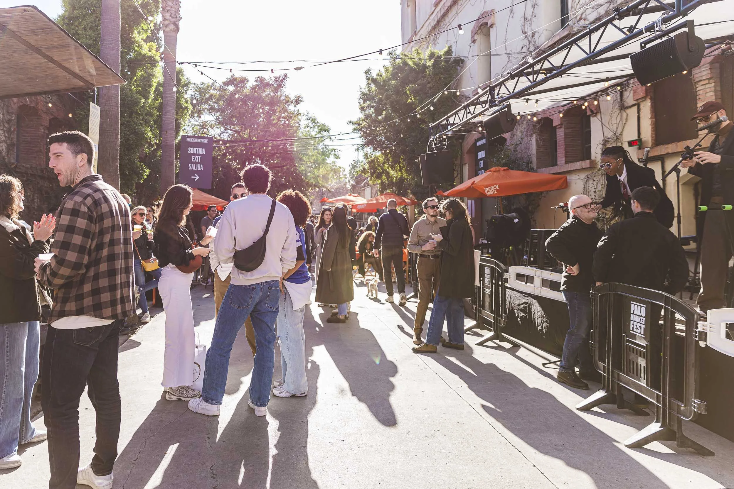 People walking between food trucks and vendor stands at an outdoor event in Barcelona