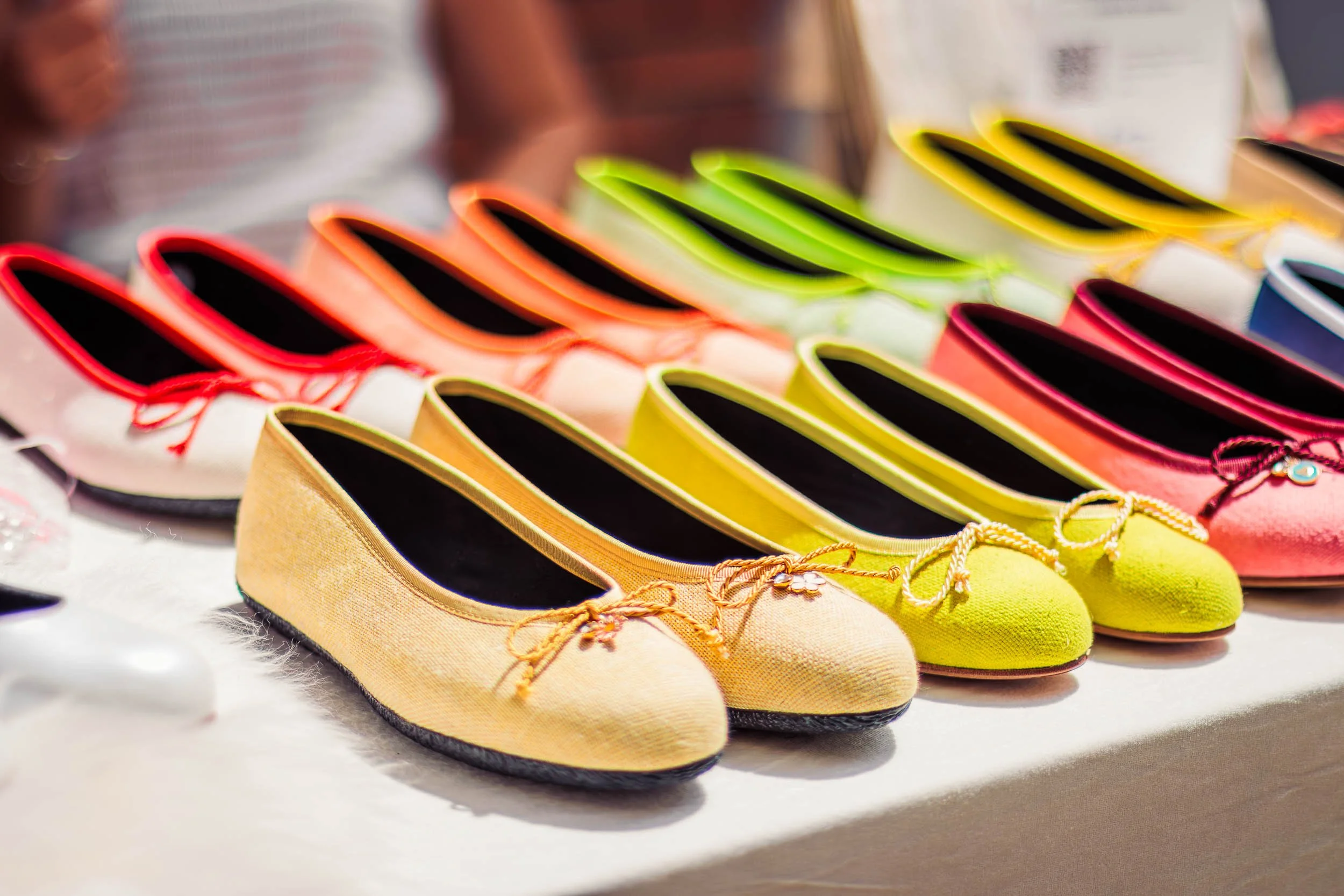 Colorful ballet flats displayed on a table.