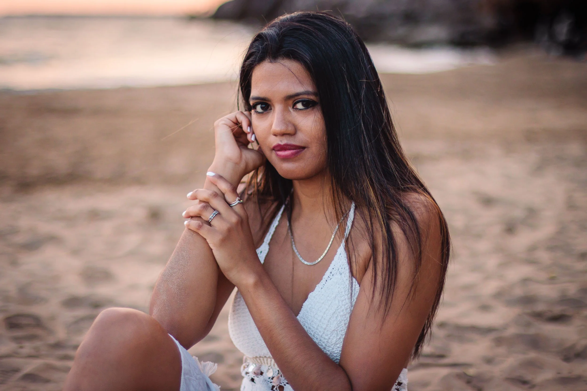 Portrait of a woman seated on the sand during a sunset beach session