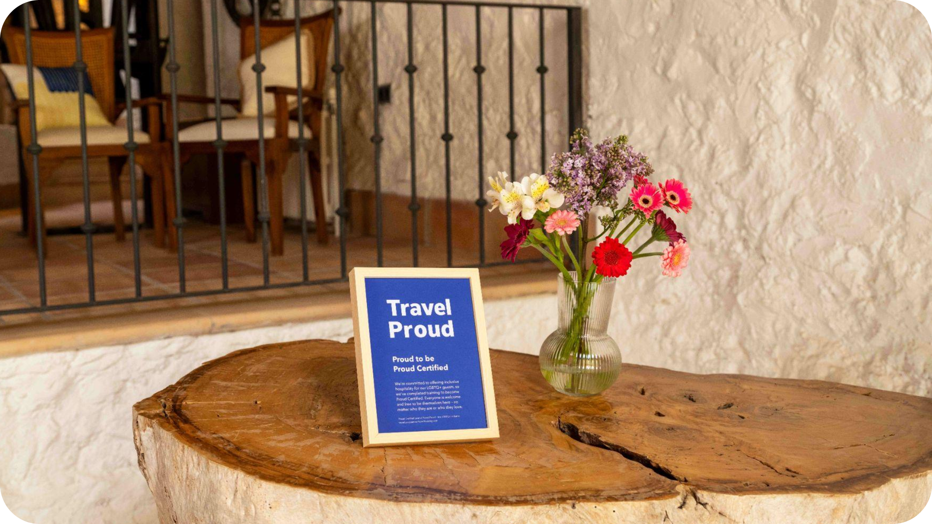 Image of a 'Travel Proud certified' sign sitting on a hotel reception desk.
