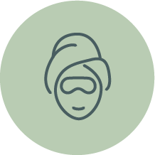 Illustration of a person with a towel wrapped around their head with cucumbers over their eyes, on a light green background.
