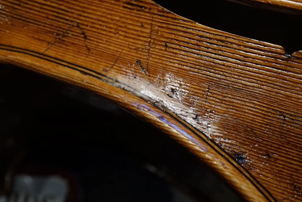 木製の家具の角に亀裂と傷があり、塗装が剥がれている部分の拡大写真