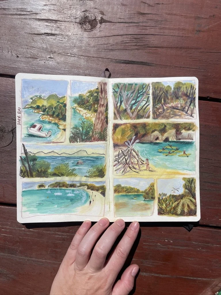 A sketchbook with watercolor drawings of a beach and nature scenes, including boats, trees, and water, labeled Lake Bay.