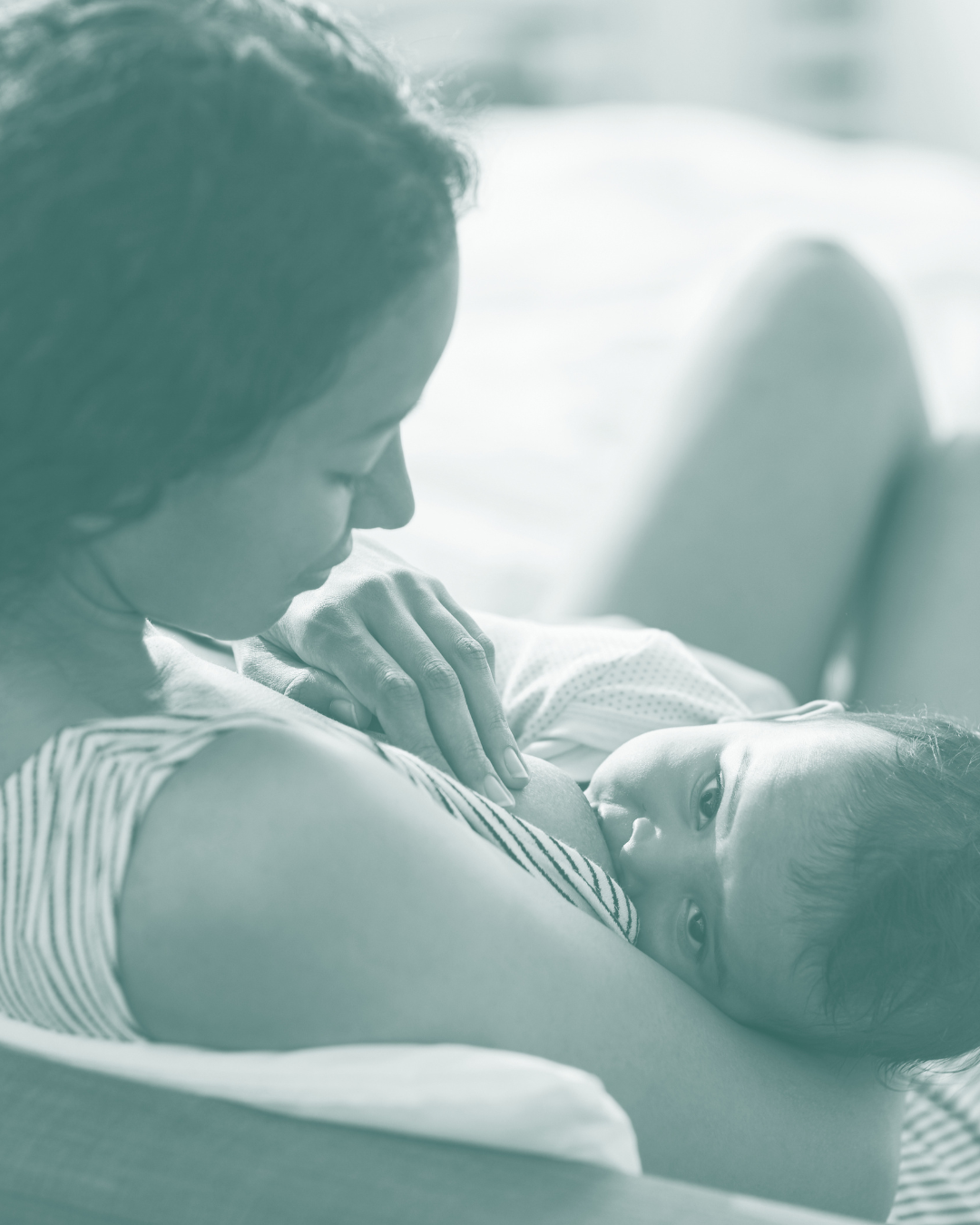 Mother breastfeeding her baby, lying on bed, bonding