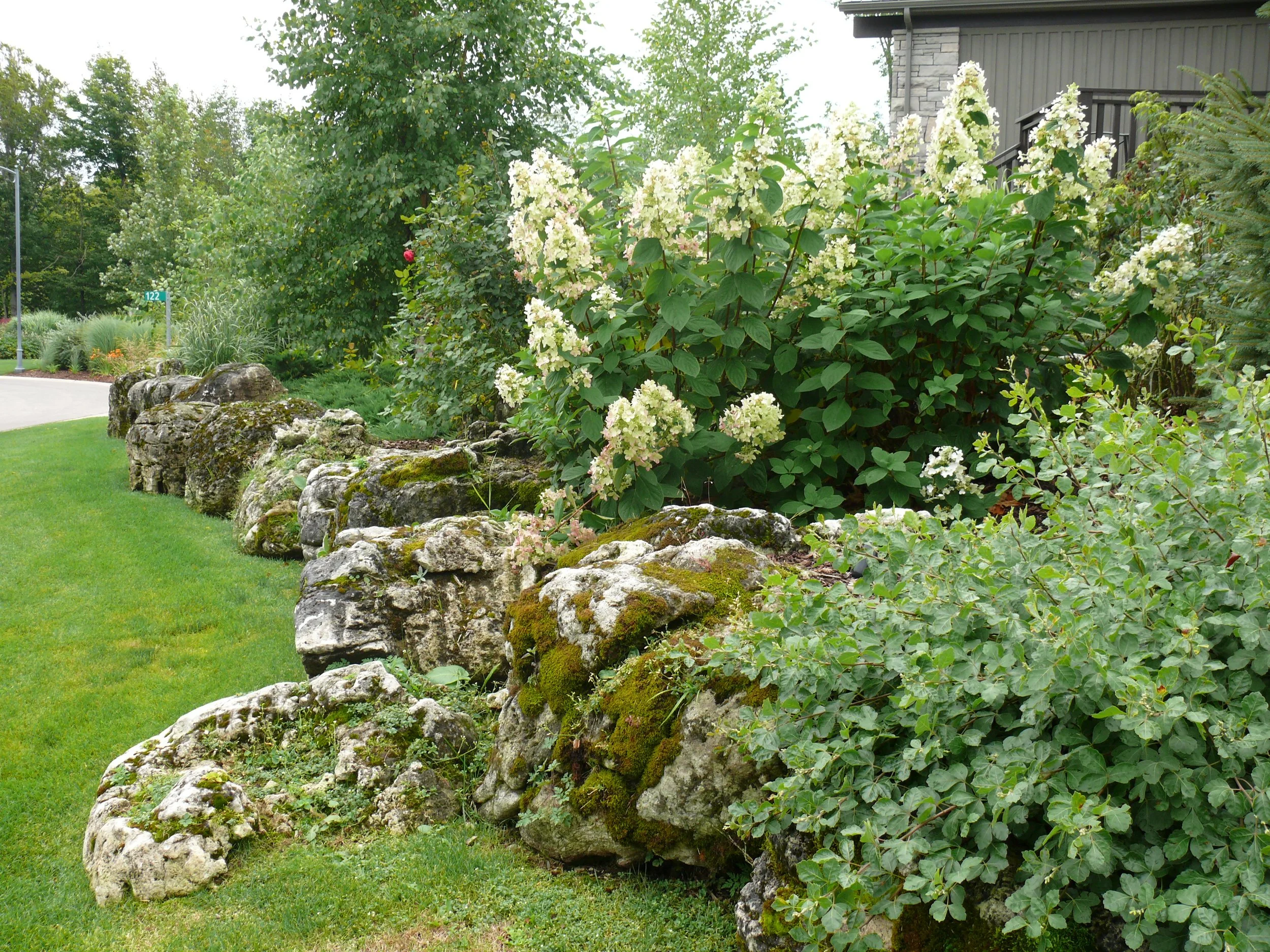 Lush gardens with weathered limestone retaining boulders