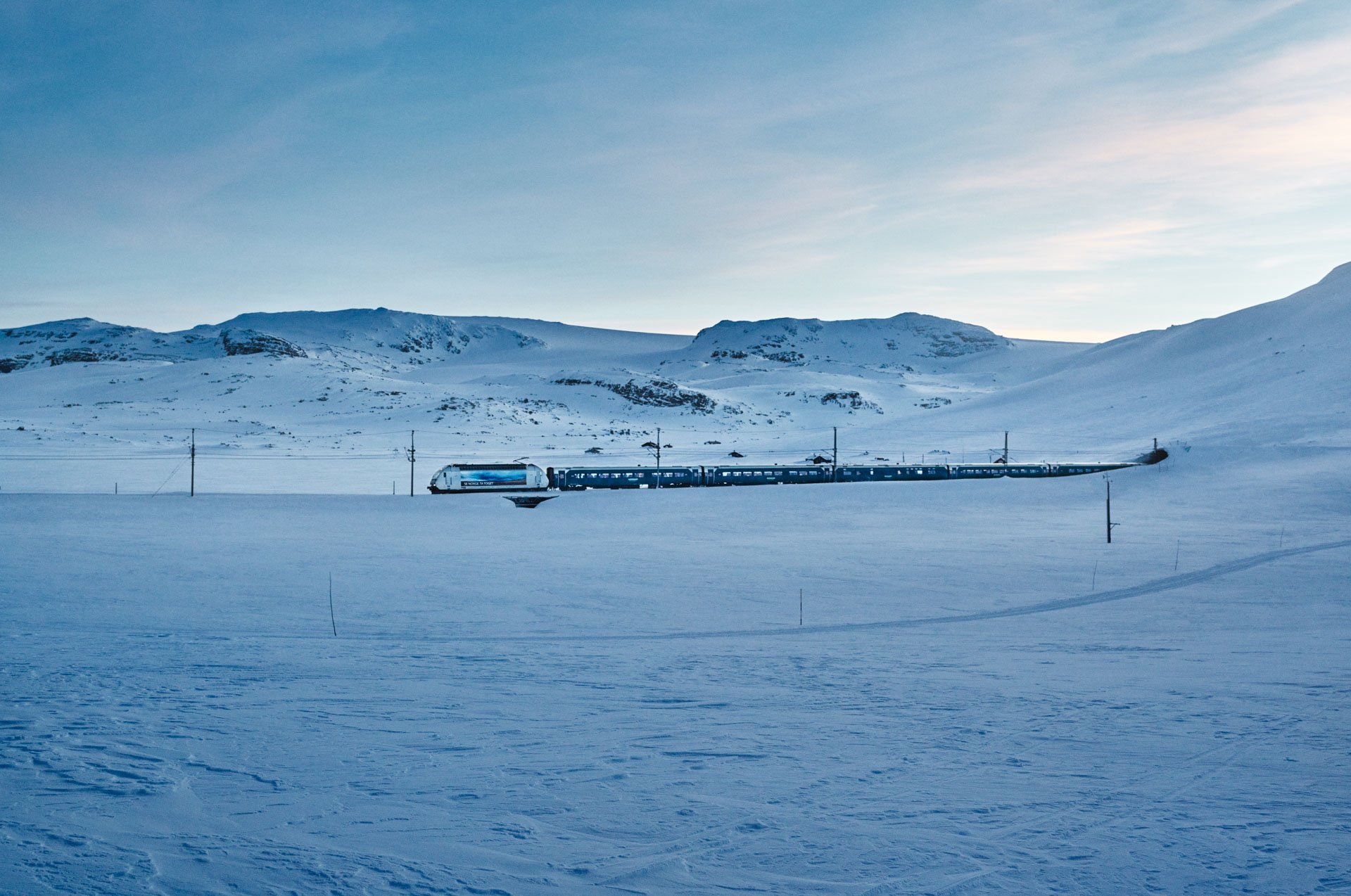 Vy train in winter landscape near Finse, Bergen Line, Norway