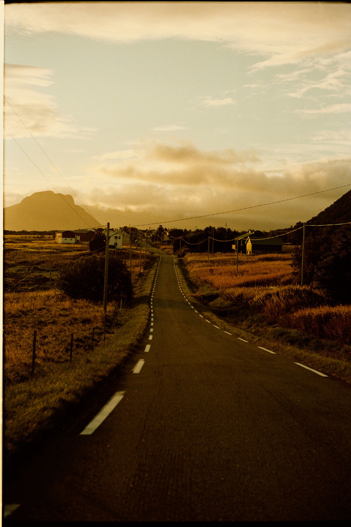 A road running towards the mountains in Lofoten in low evening light