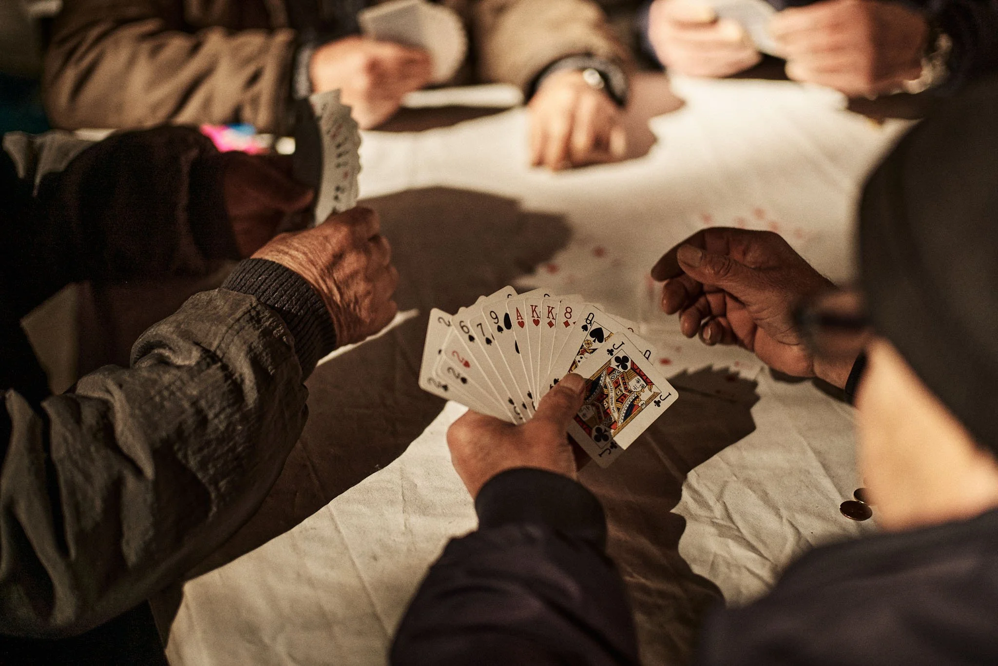 Men playing cards at a table in Catania, Sicily, travel photography by Oivind Haug