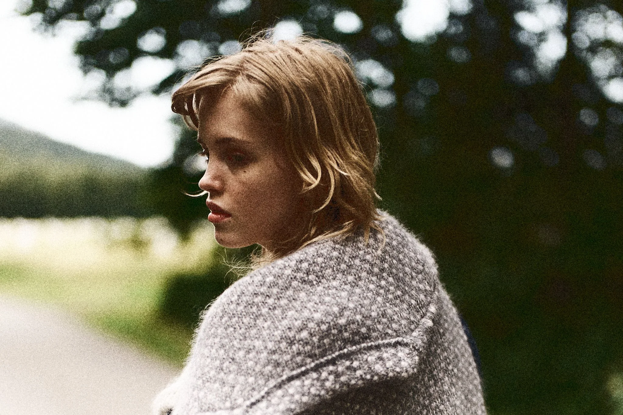 Young woman in a grey wool cardigan in soft summer light, fashion and lifestyle photography by Oivind Haug