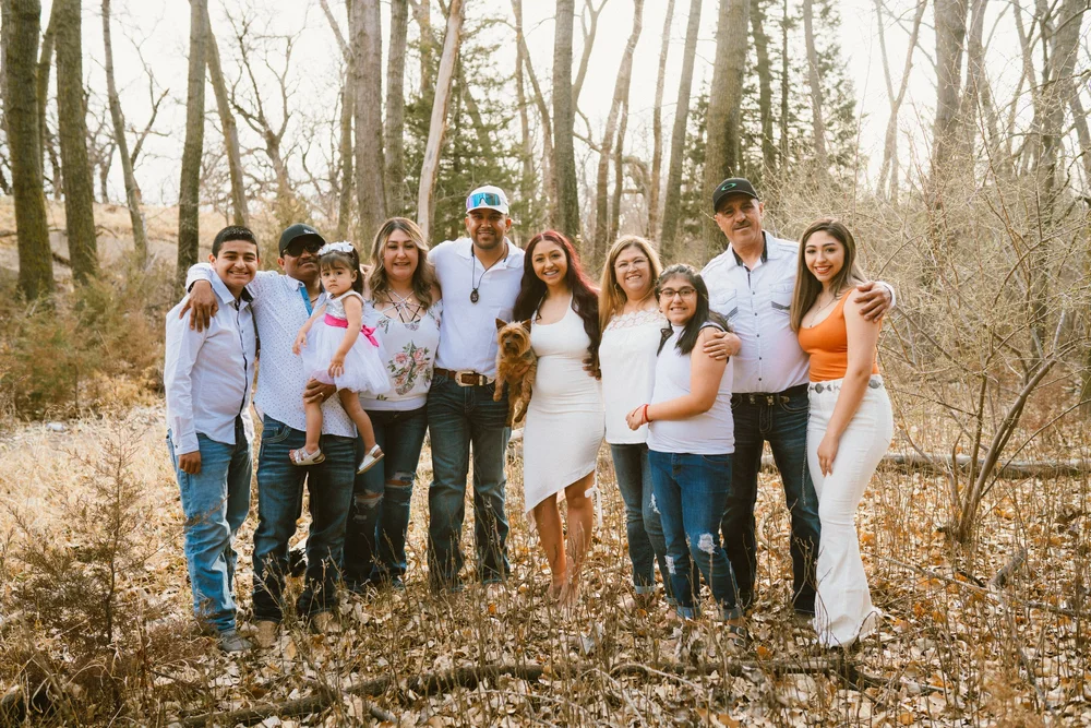 A large multigenerational family in a wooded area in autumn