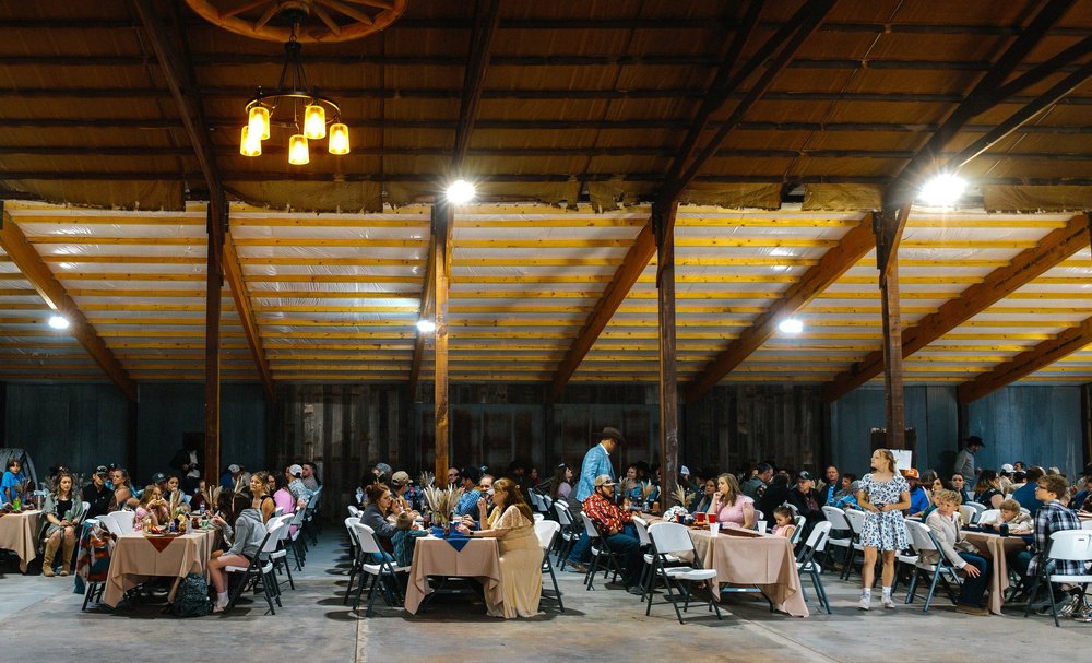 Wedding reception in a rustic barn with guests at tables