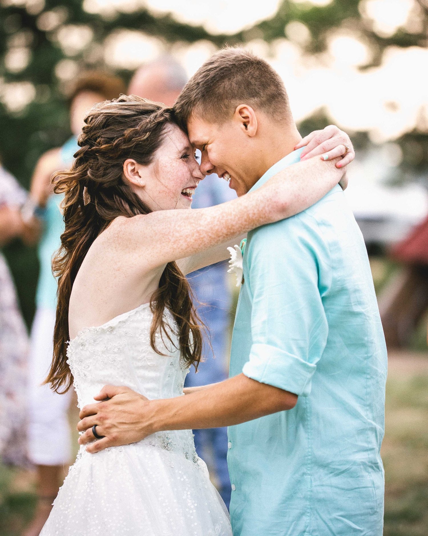 A couple dancing outdoors with foreheads touching at their wedding