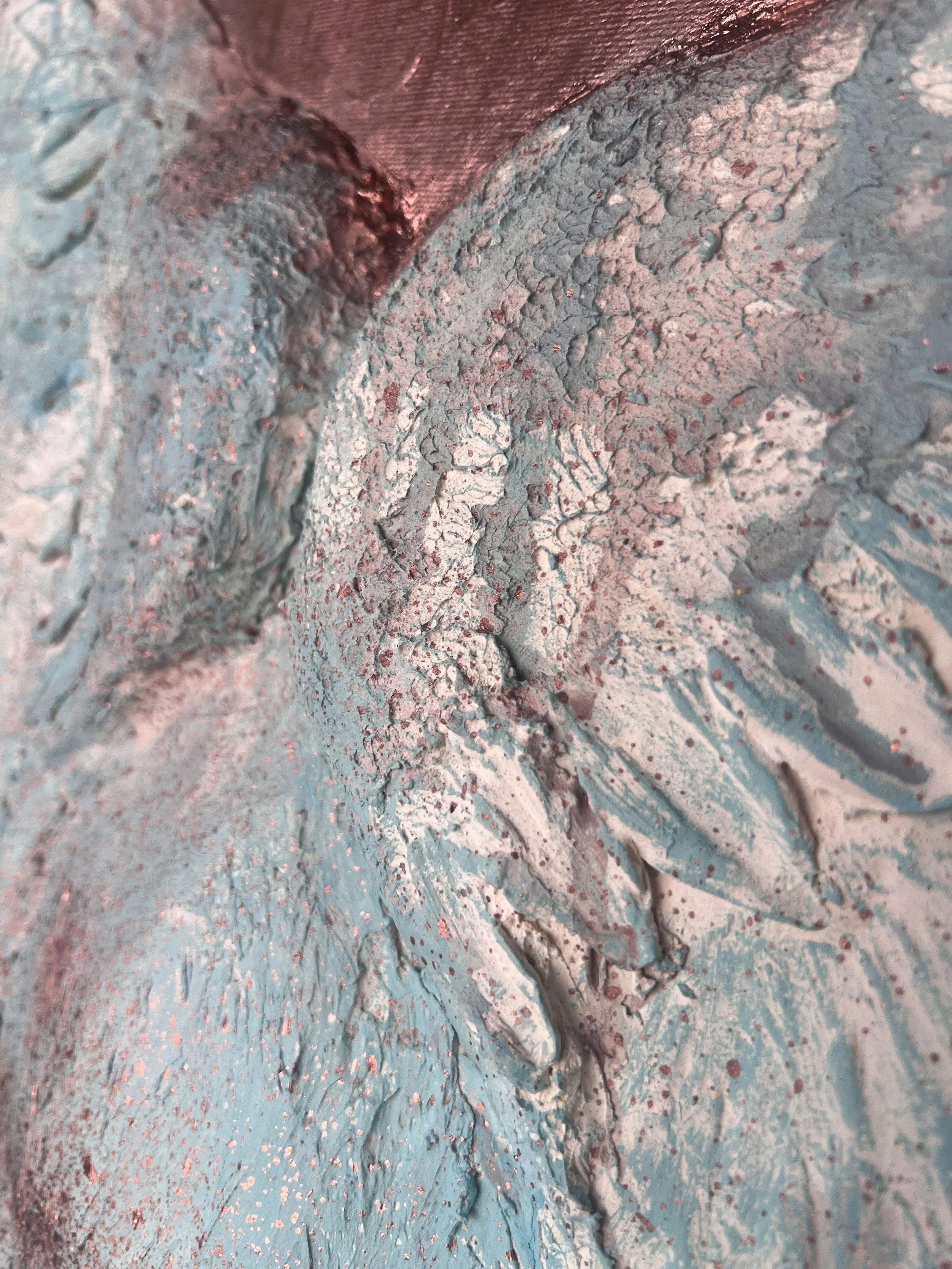 Close-up view of a textured, cracked surface covered in light blue and pinkish dust or powder.