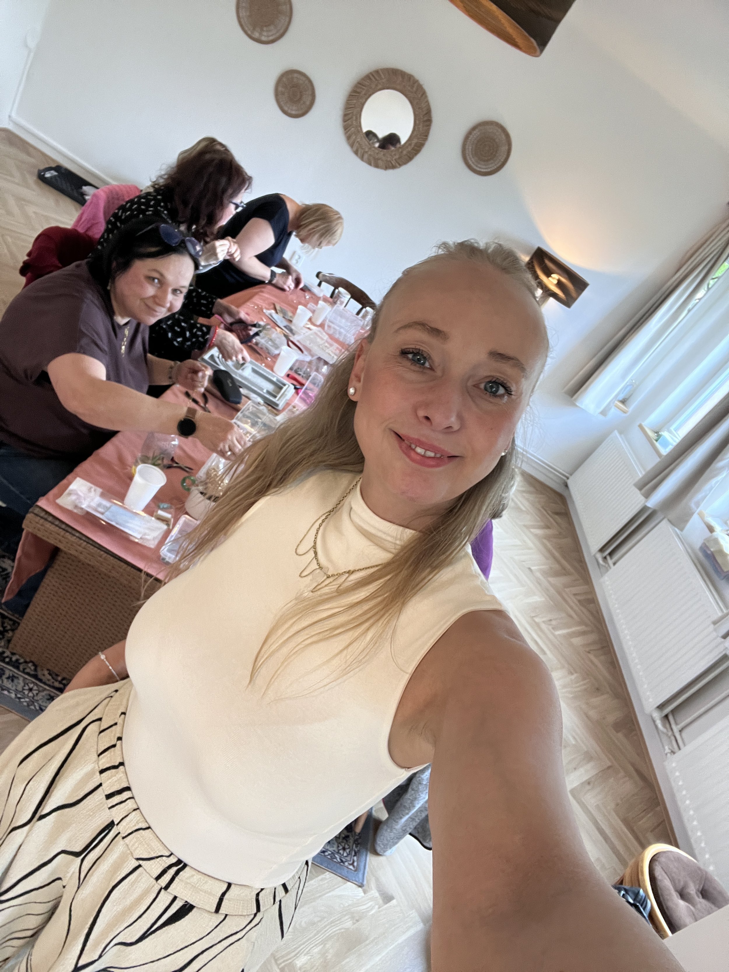 Žena, která pořádá kurzy výroby šperku v Praze pro skupinu žen . Šperky se vyrábějí z pravých říčních perel.