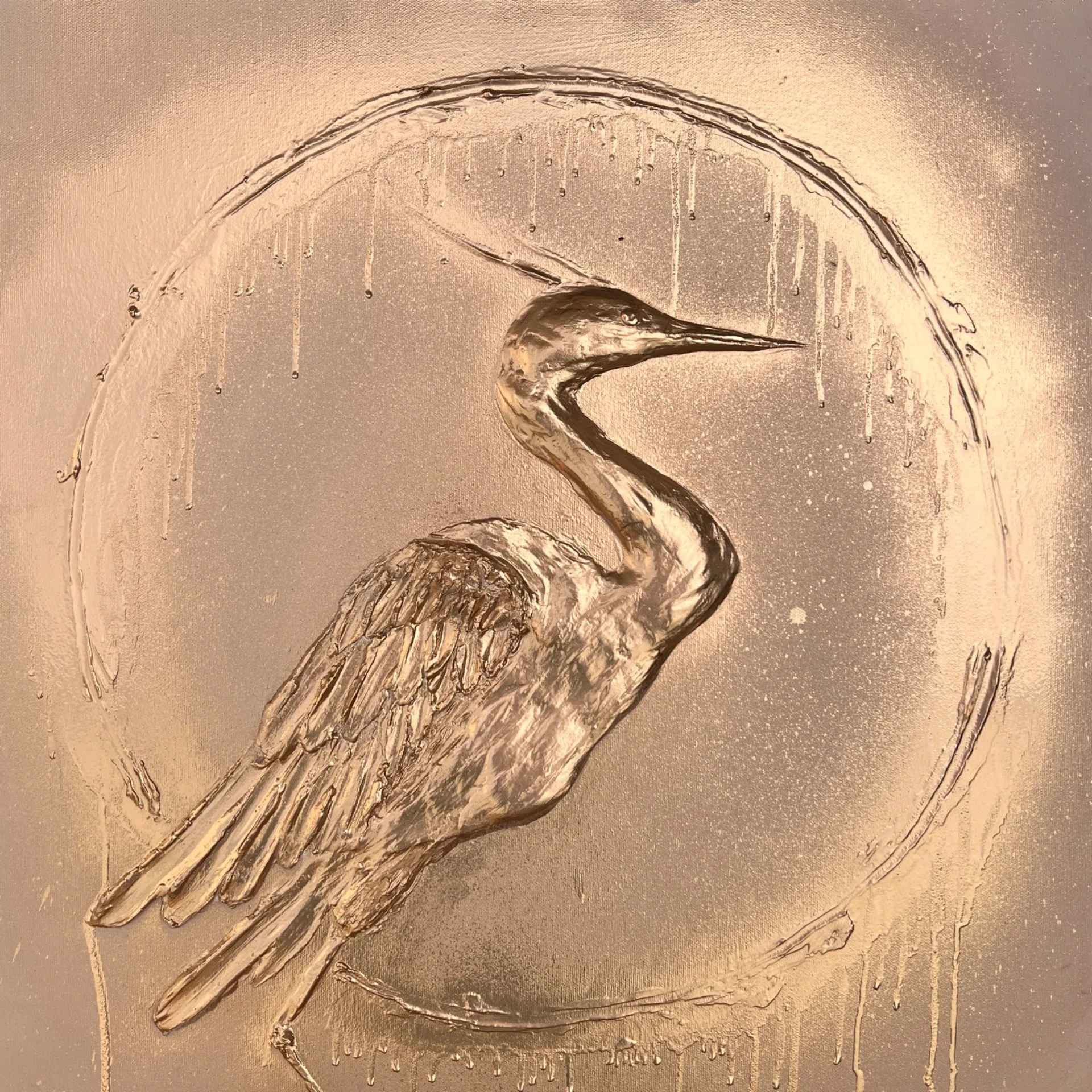 Gold-colored metal relief of a heron inside a circular frame, featuring detailed feathers and a curved neck.