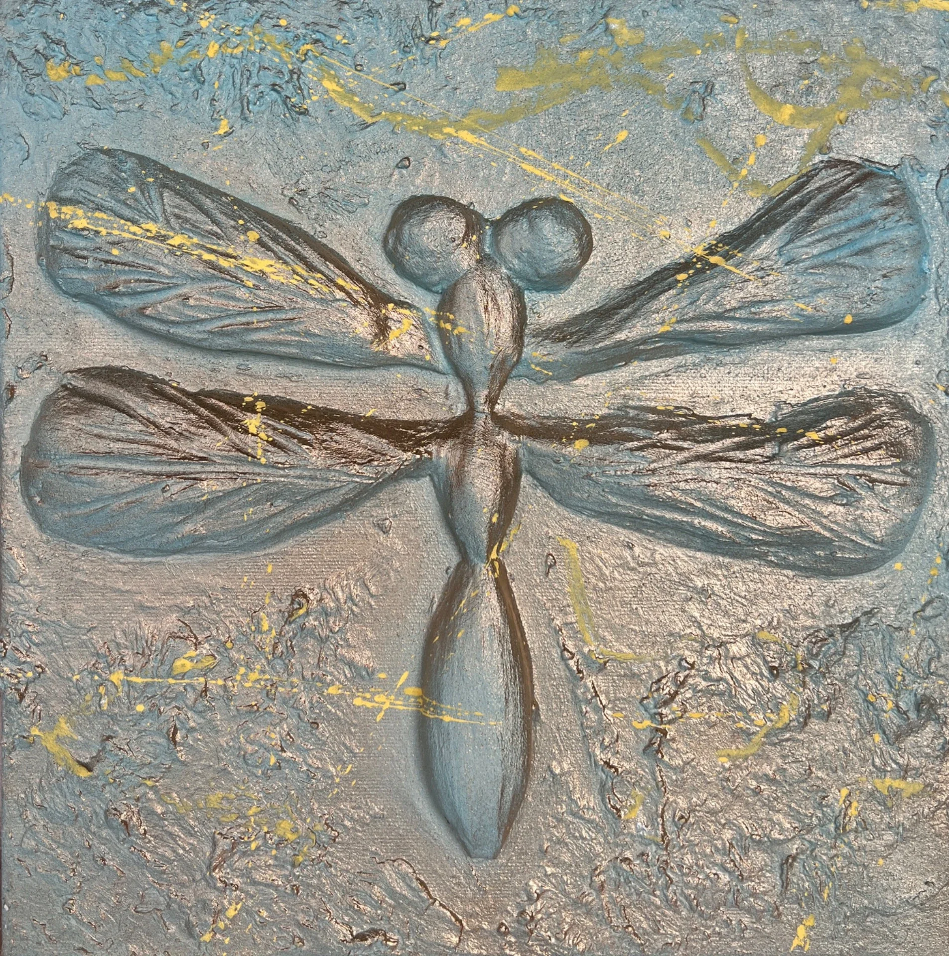 A textured painting of a dragonfly with blue and gray hues, featuring yellow splatter accents, on a rough, gray background.
