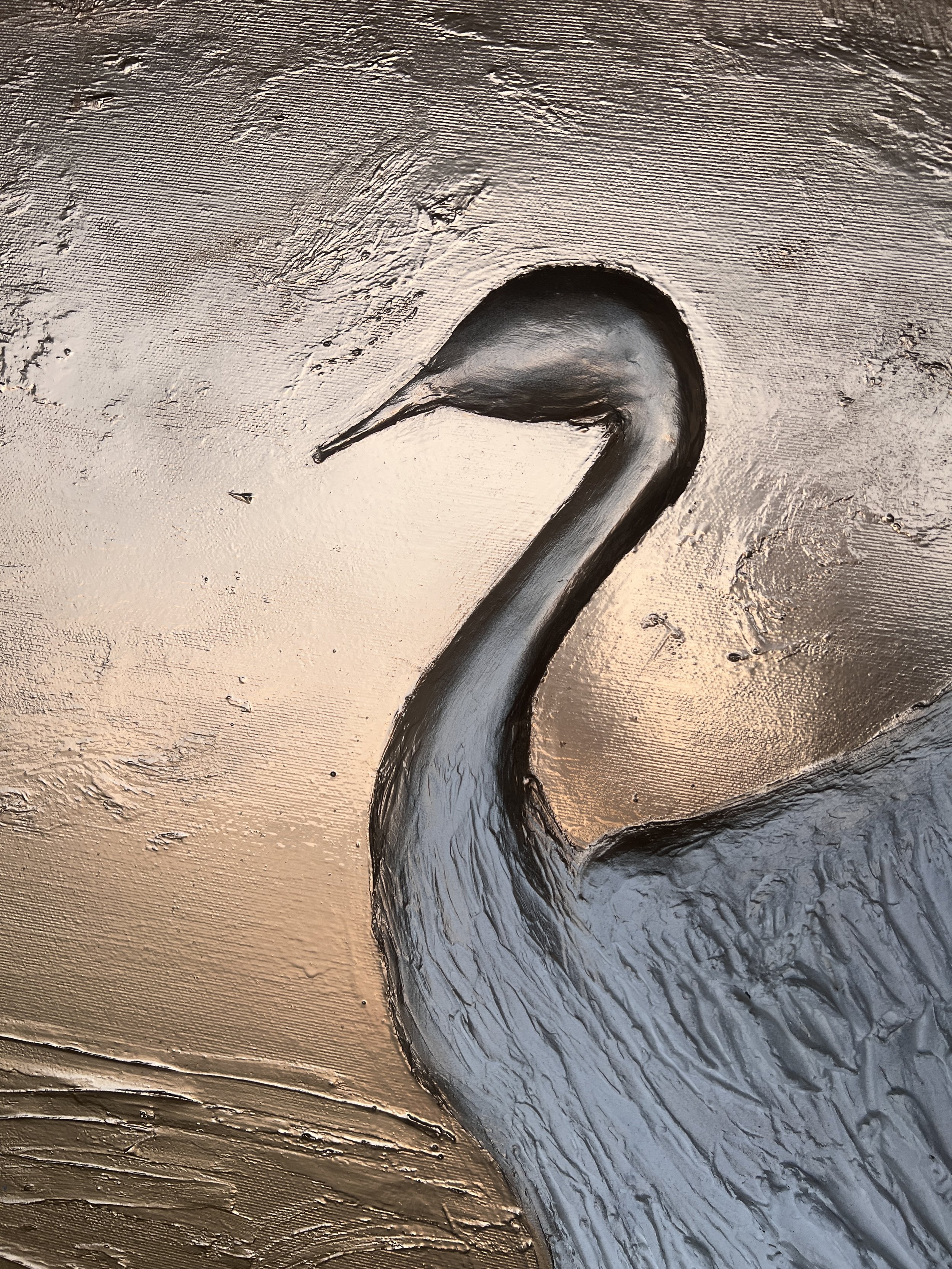 Close-up of a textured metal relief sculpture of a swan, capturing the neck and part of the body against a metallic background.