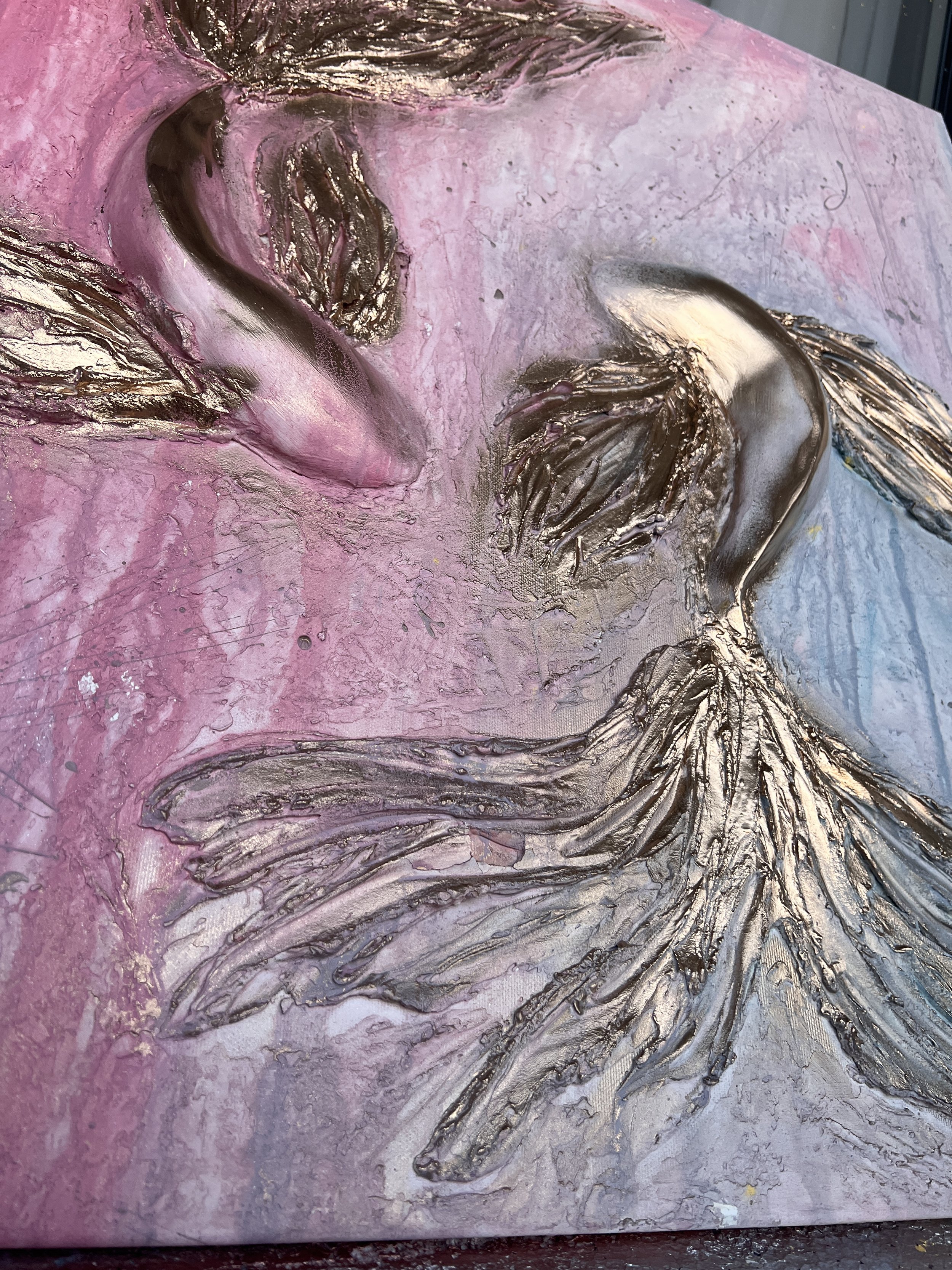Close-up of an abstract painting featuring a face with closed eyes, in pink, silver, and blue hues, with metallic and textured details.