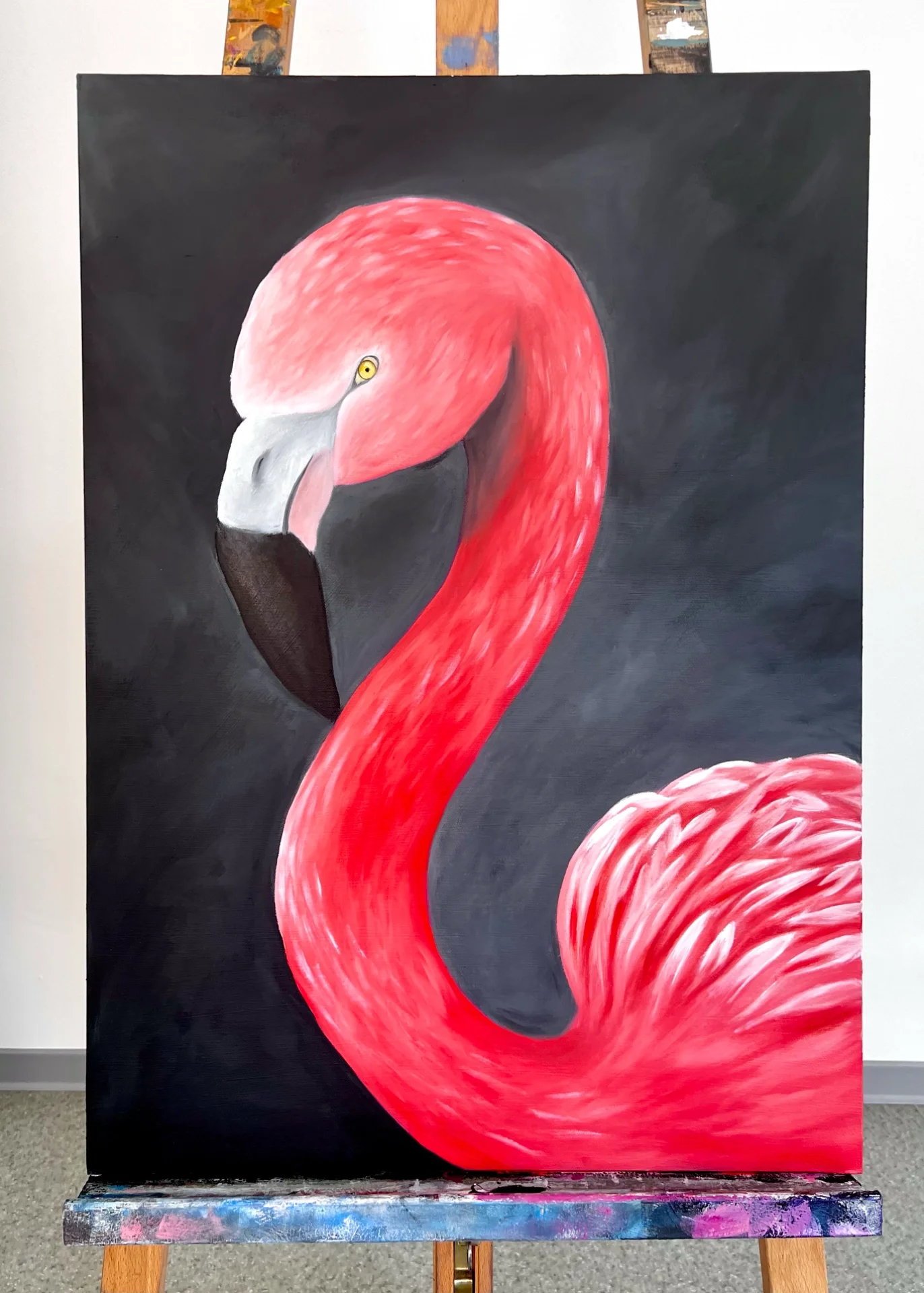 A painting of a pink flamingo with a black background. The flamingo's head is tilted downward, and its long, curved neck dominates the composition.