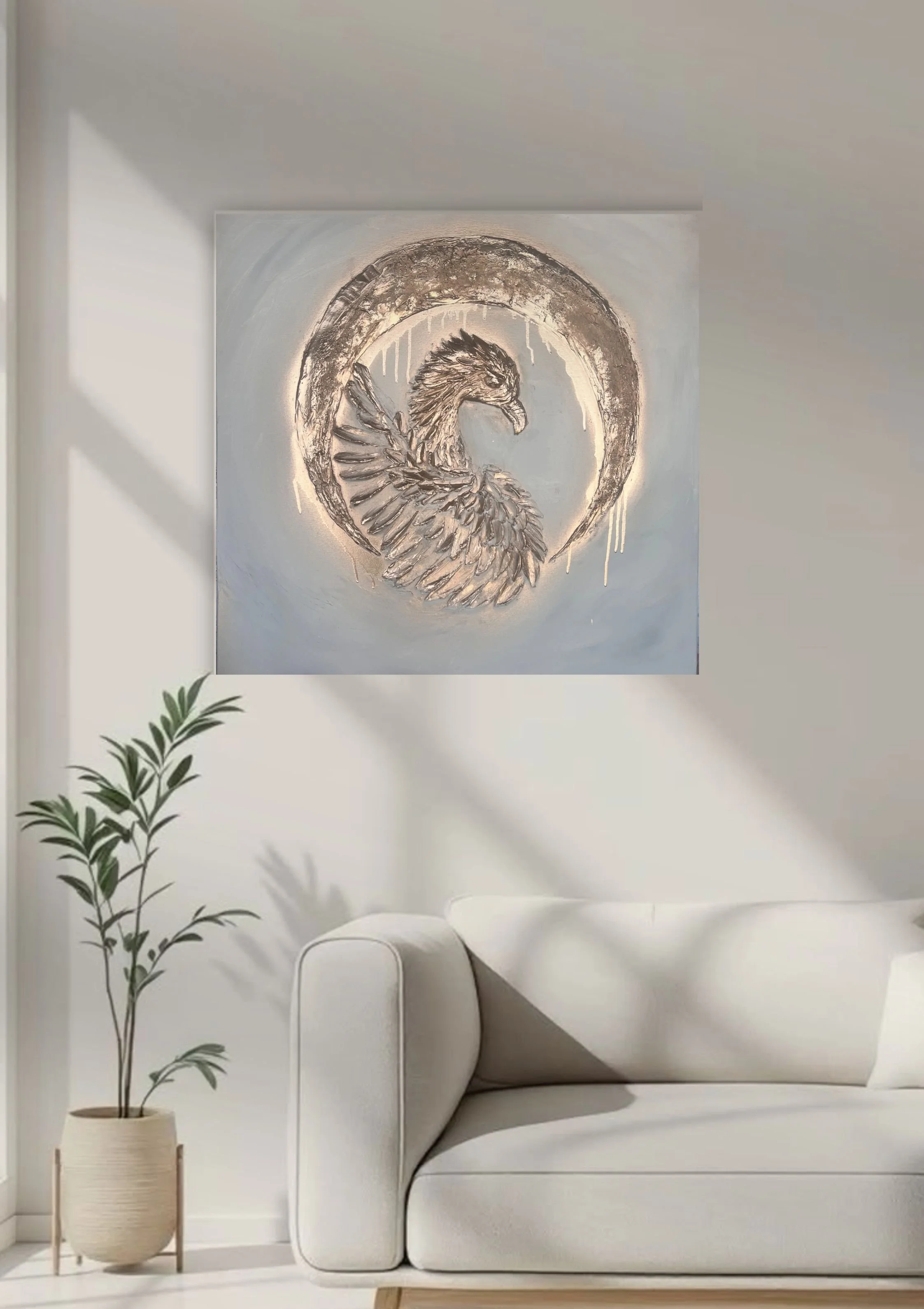 A modern living room with a white sofa, potted plant, and a metallic artwork of a bird within a circular frame on the wall.