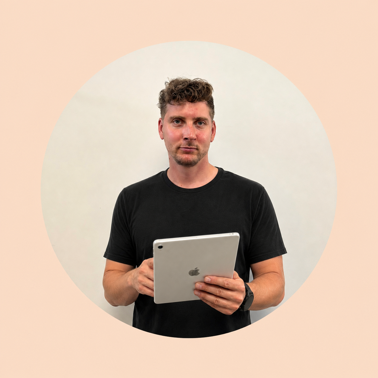 Ein Mann hält ein iPad und schaut in die Kamera, trägt ein schwarzes T-Shirt, steht vor einer weißen Wand, mit digitalem Design im Hintergrund.