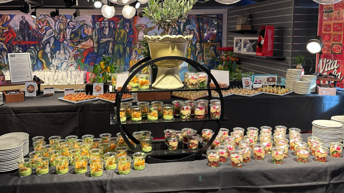 Buffet mit kleinen Speisen im Glas, auf Platten und auf einer Etagere.