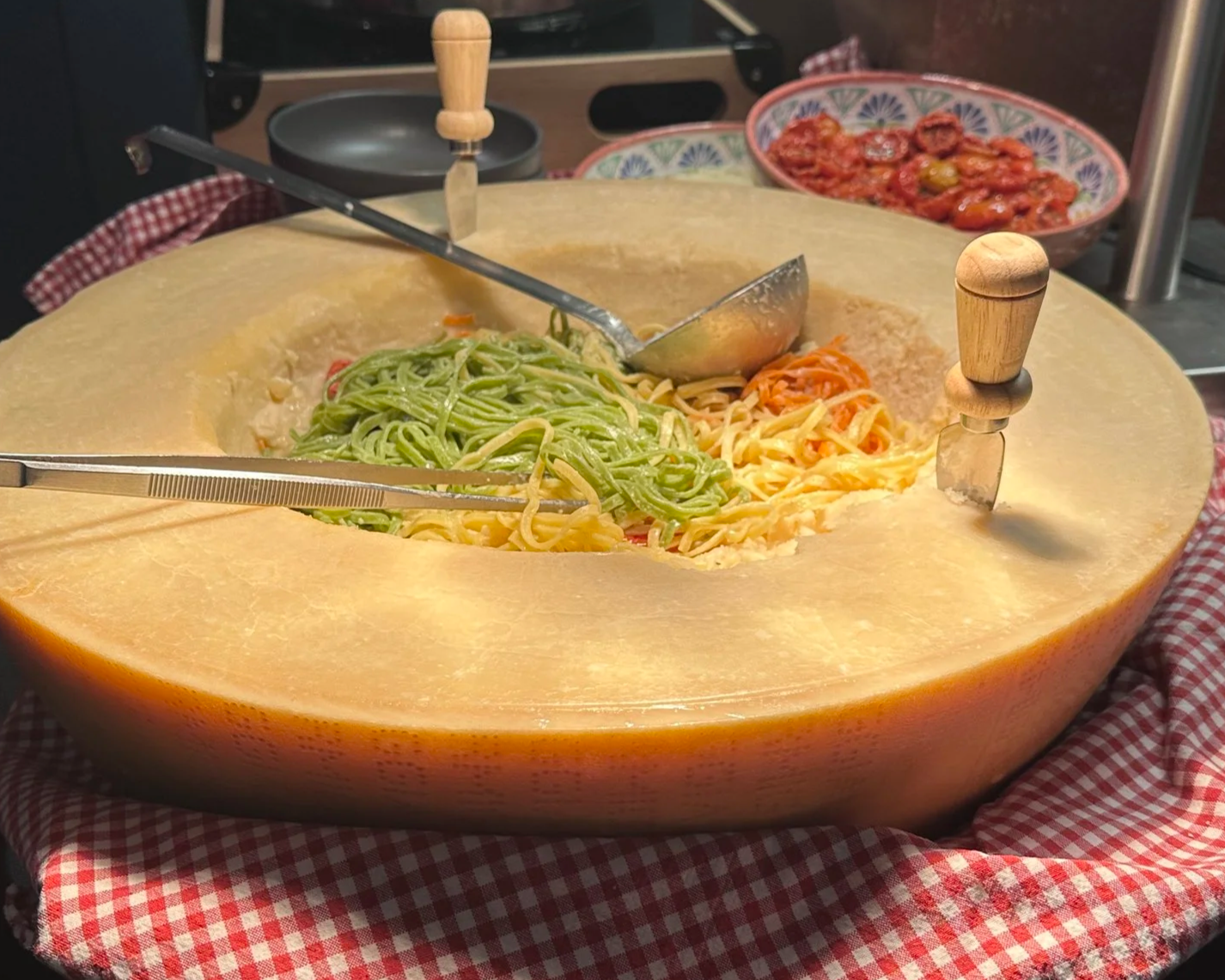 Pasta mit verschiedenen Toppings in einem großen ausgehöhlten Parmesan-Käselaib.