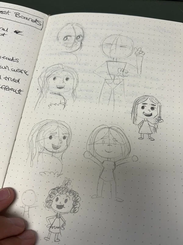 Page from a notebook with multiple hand-drawn cartoon characters, including girls with various hairstyles, a character with glasses, and a character with curly hair.