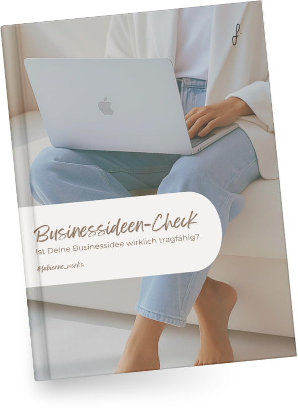 Ein person sitzt auf einem weißen Sofa, trägt eine weiße Jacke und blaue Jeans, und arbeitet an einem silbernen MacBook, das auf den Beinen liegt. Der Buchumschlag zeigt den Titel "Businessideen-Check" und den Untertitel "Ist Deine Businessidee wirklich tragfähig?"