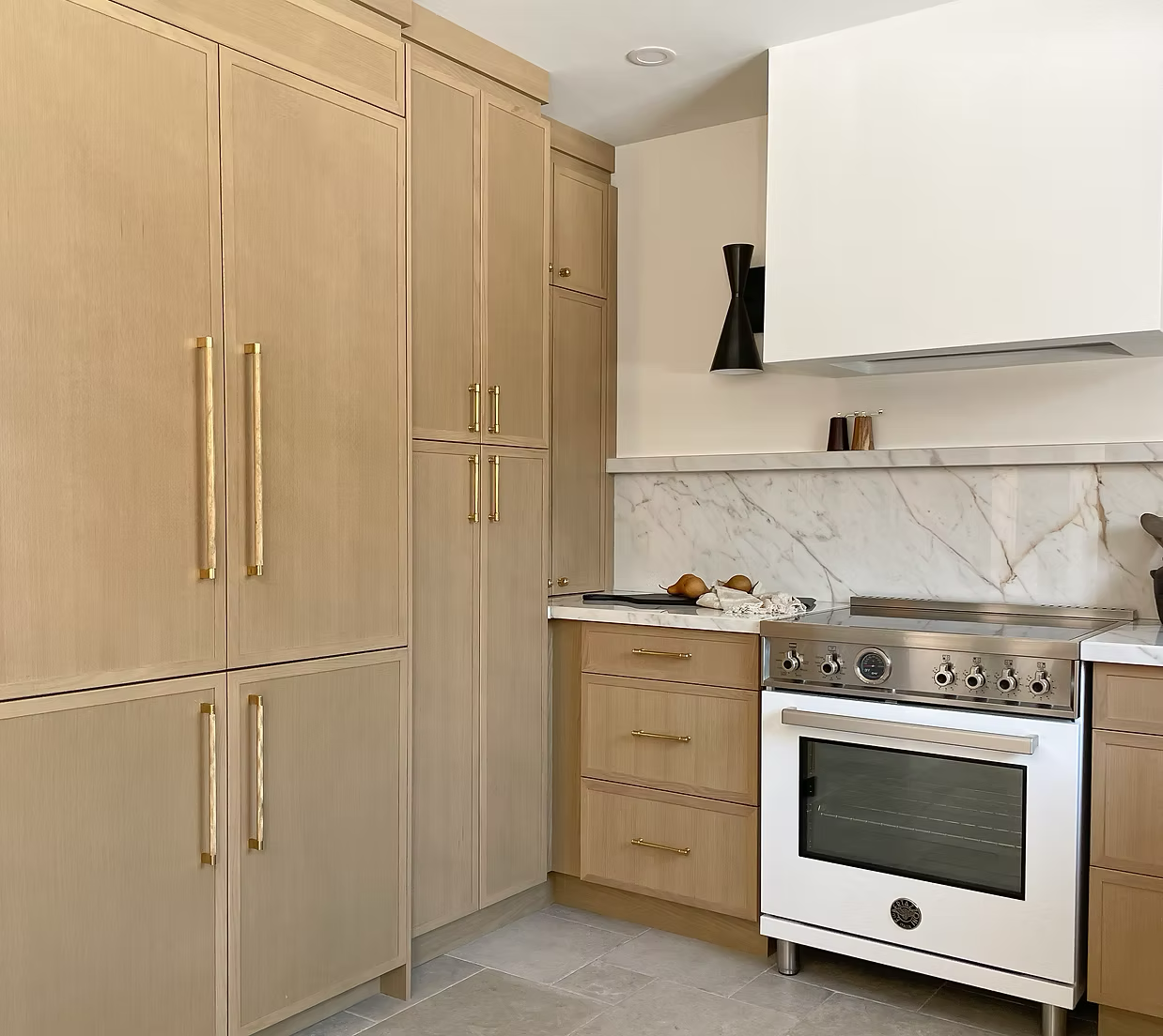 Kitchen with wooden cabinets, a white oven, and a marble backsplash.