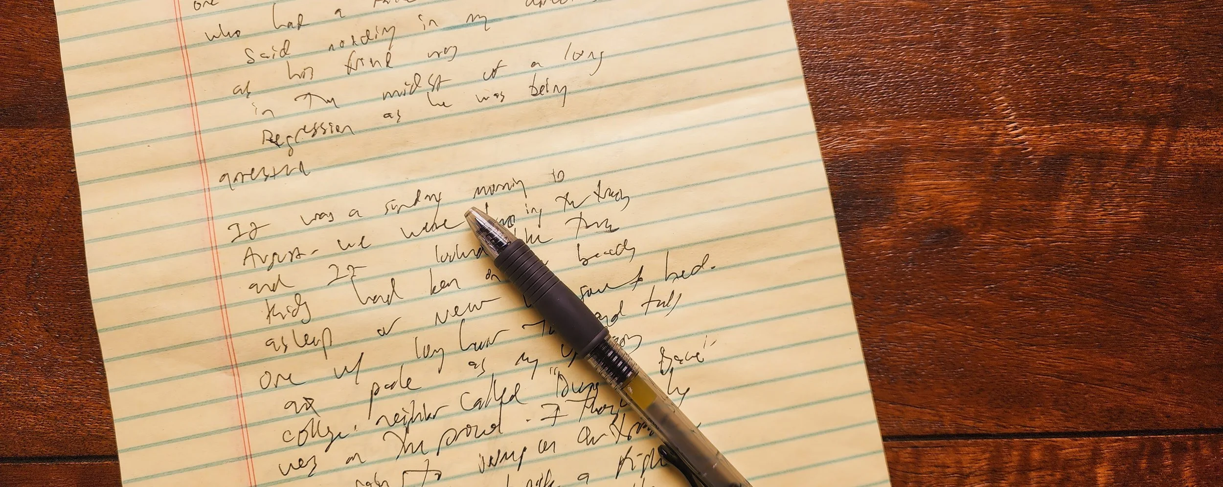 Handwritten poem on a yellow legal pad with black pen