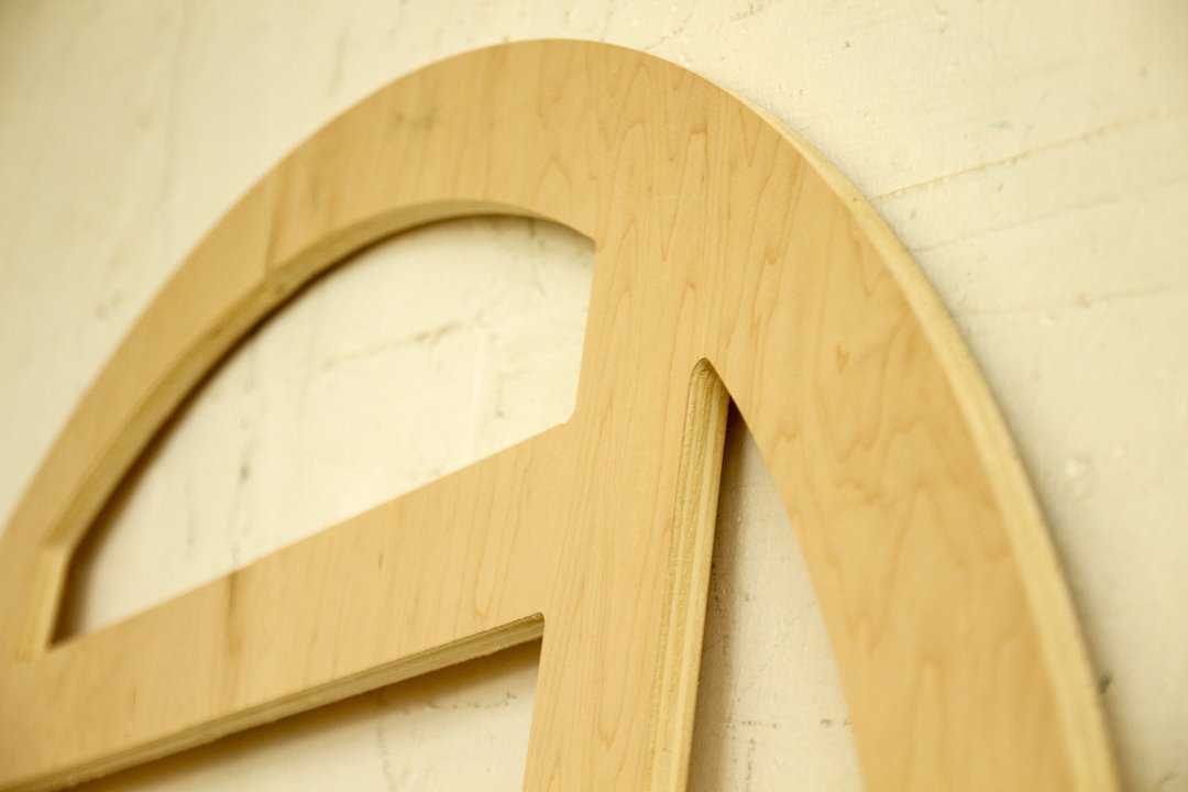Close-up of a wooden letter 'e' mounted on a light-colored wall.